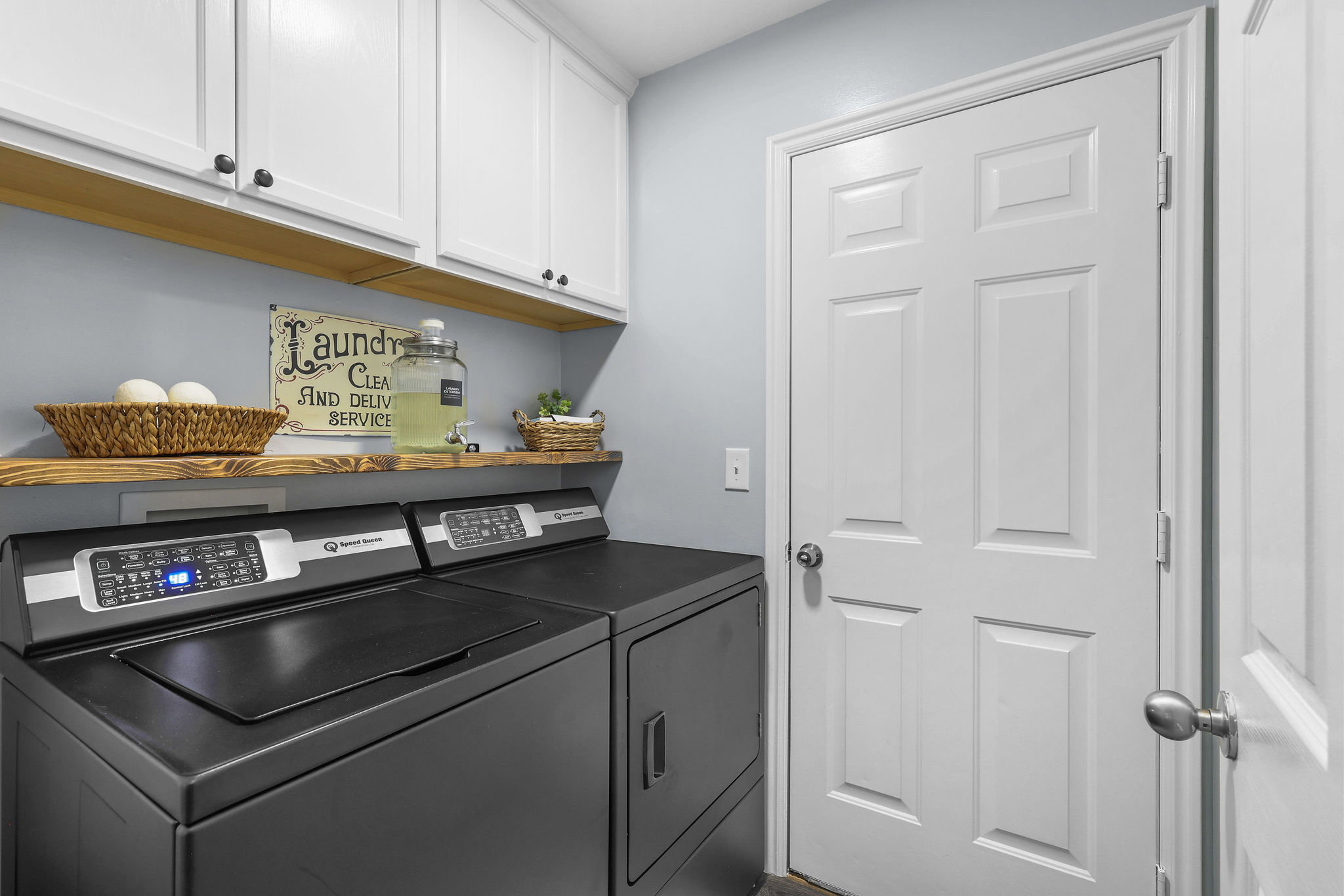 Laundry room with additional storage, door to attached garage