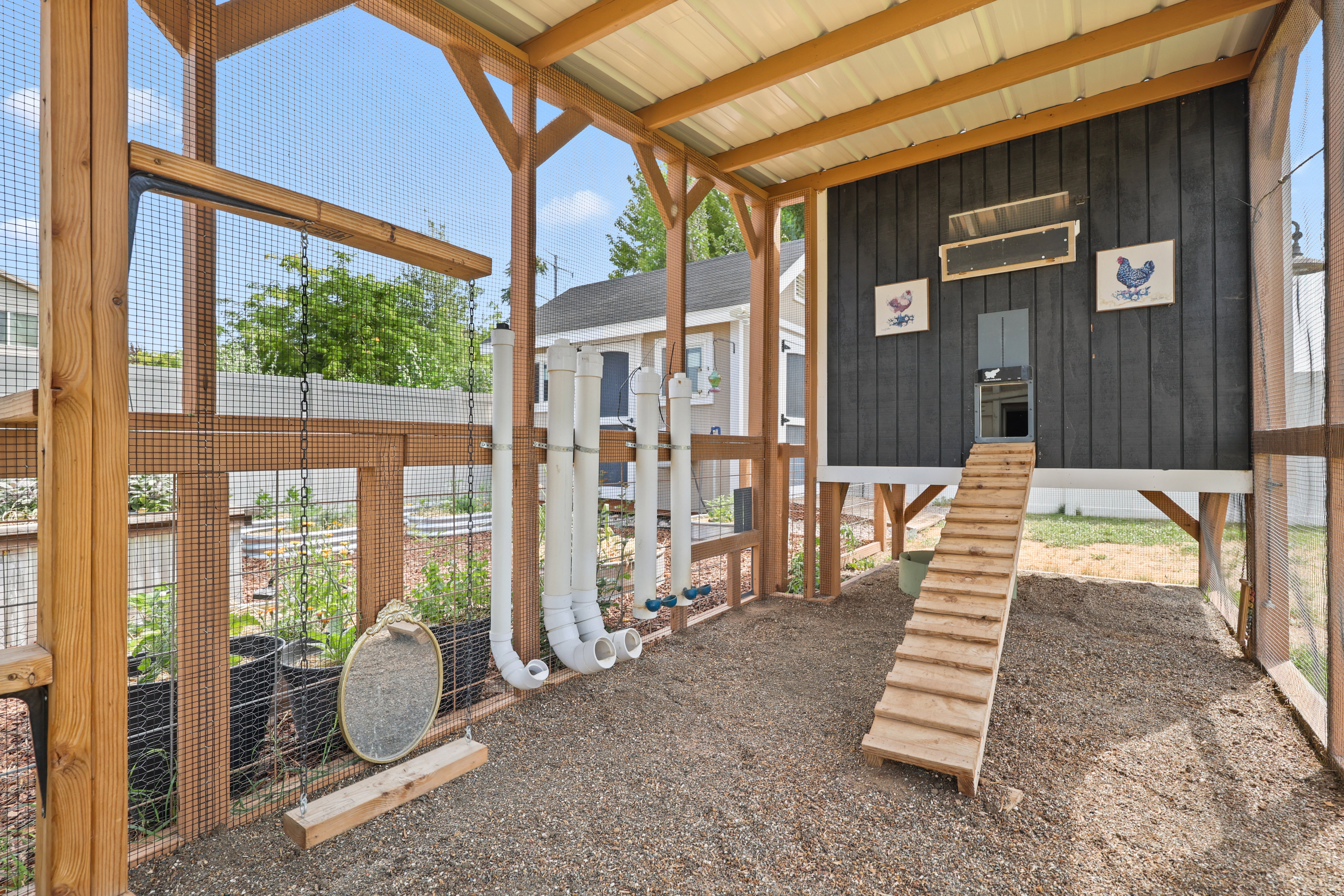 interior of Custom-built chicken coop featuring a dark paneled exterior, elevated structure, and a natural wood ramp