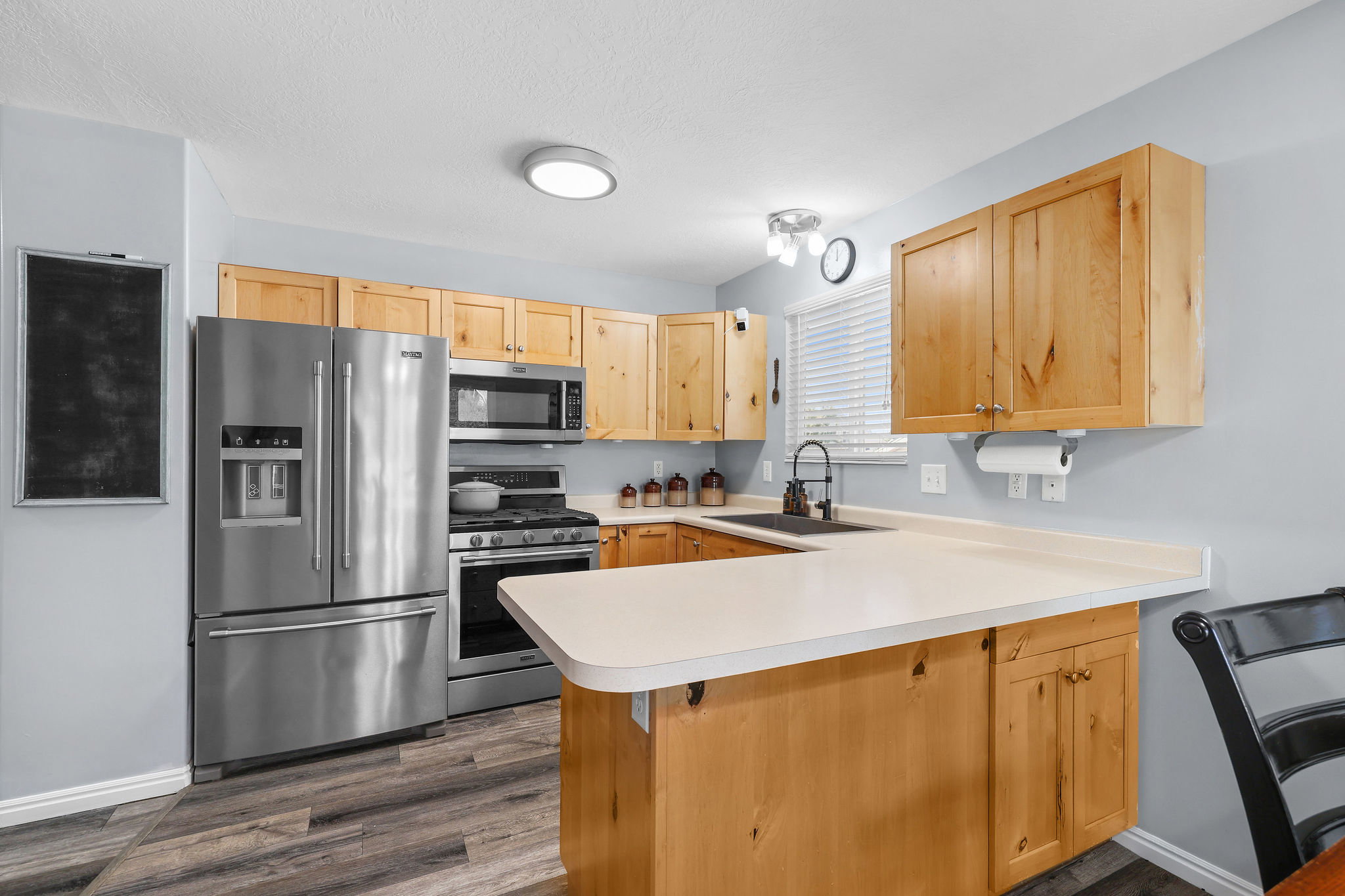Kitchen featuring light wood cabinetry, stainless steel appliances