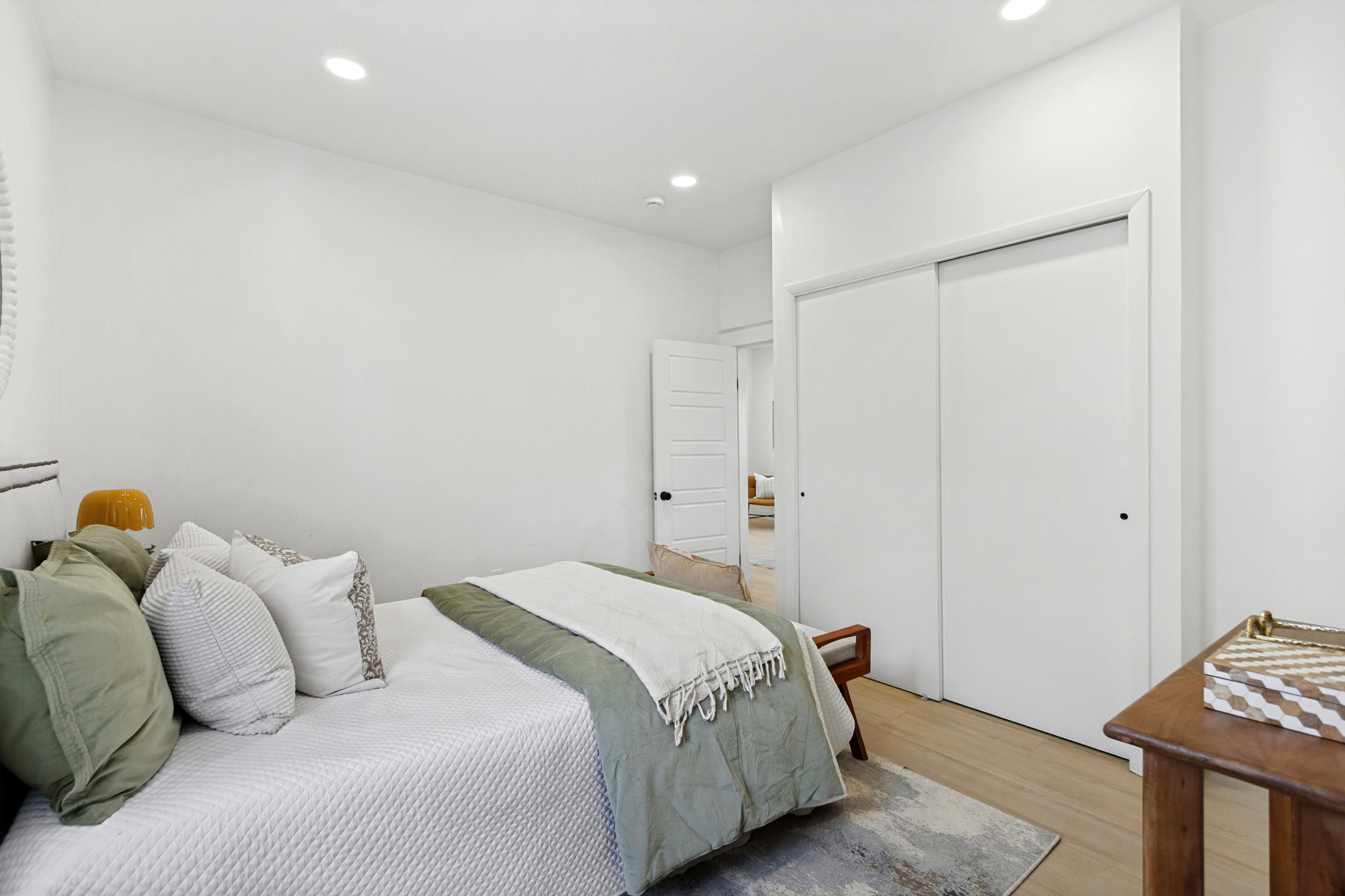 Bedroom featuring light wood-finish flooring, recessed lighting, and a white sliding closet door