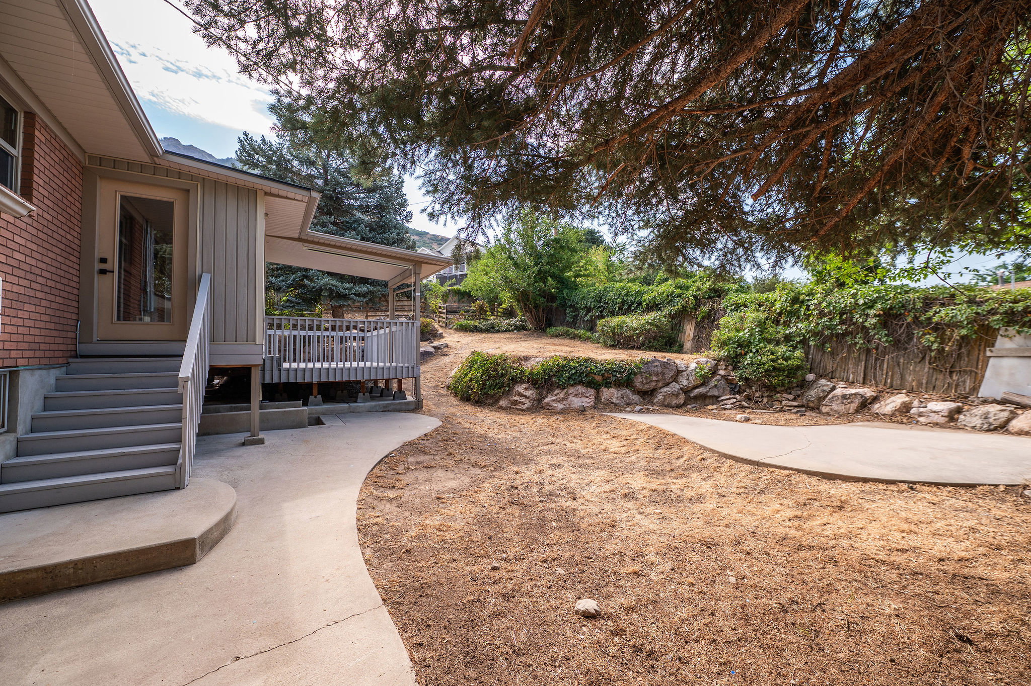 Covered outdoor deck with light gray railing and stairs