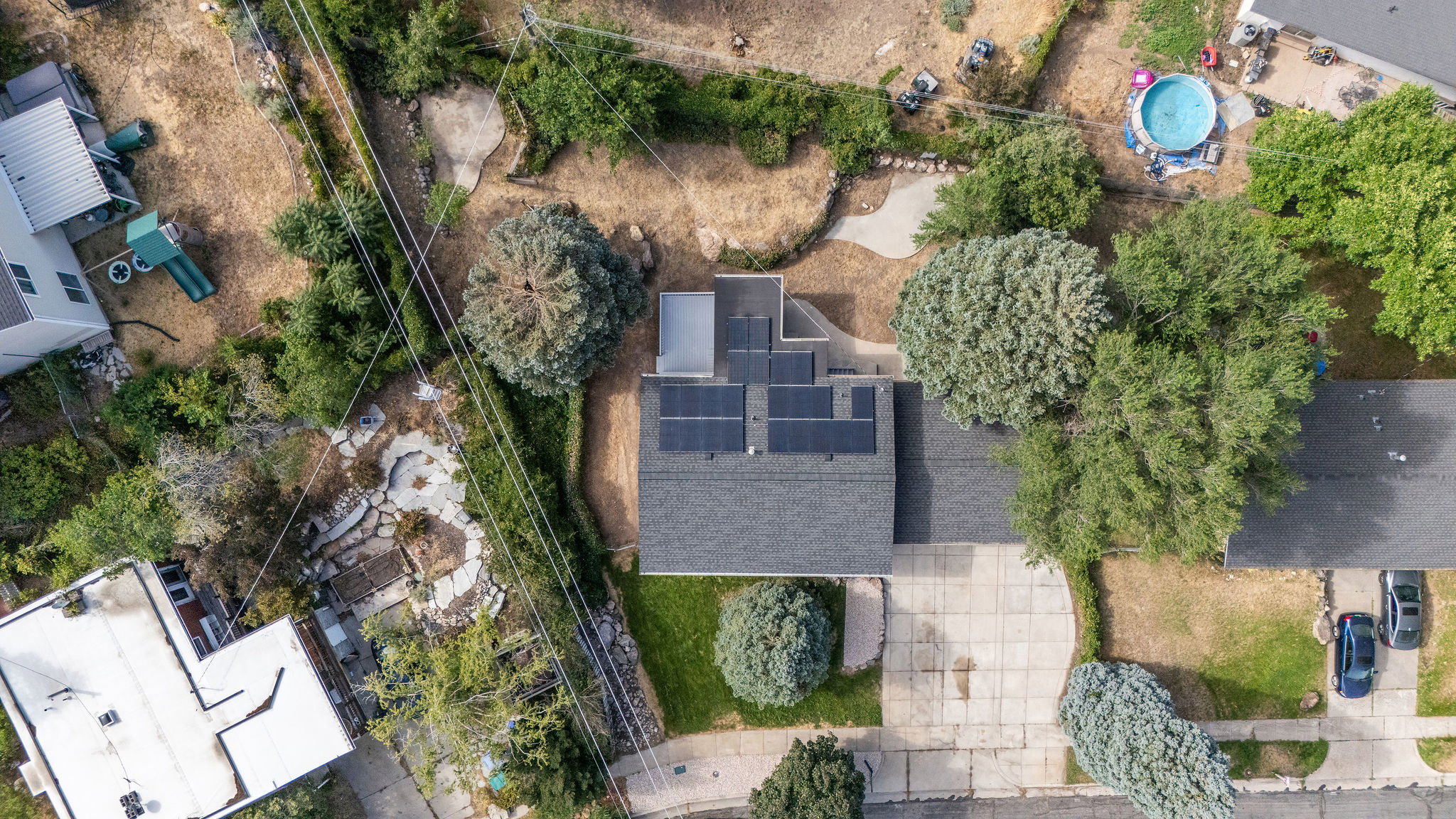 Property featuring a gray shingle roof, multiple solar panels, and a concrete driveway