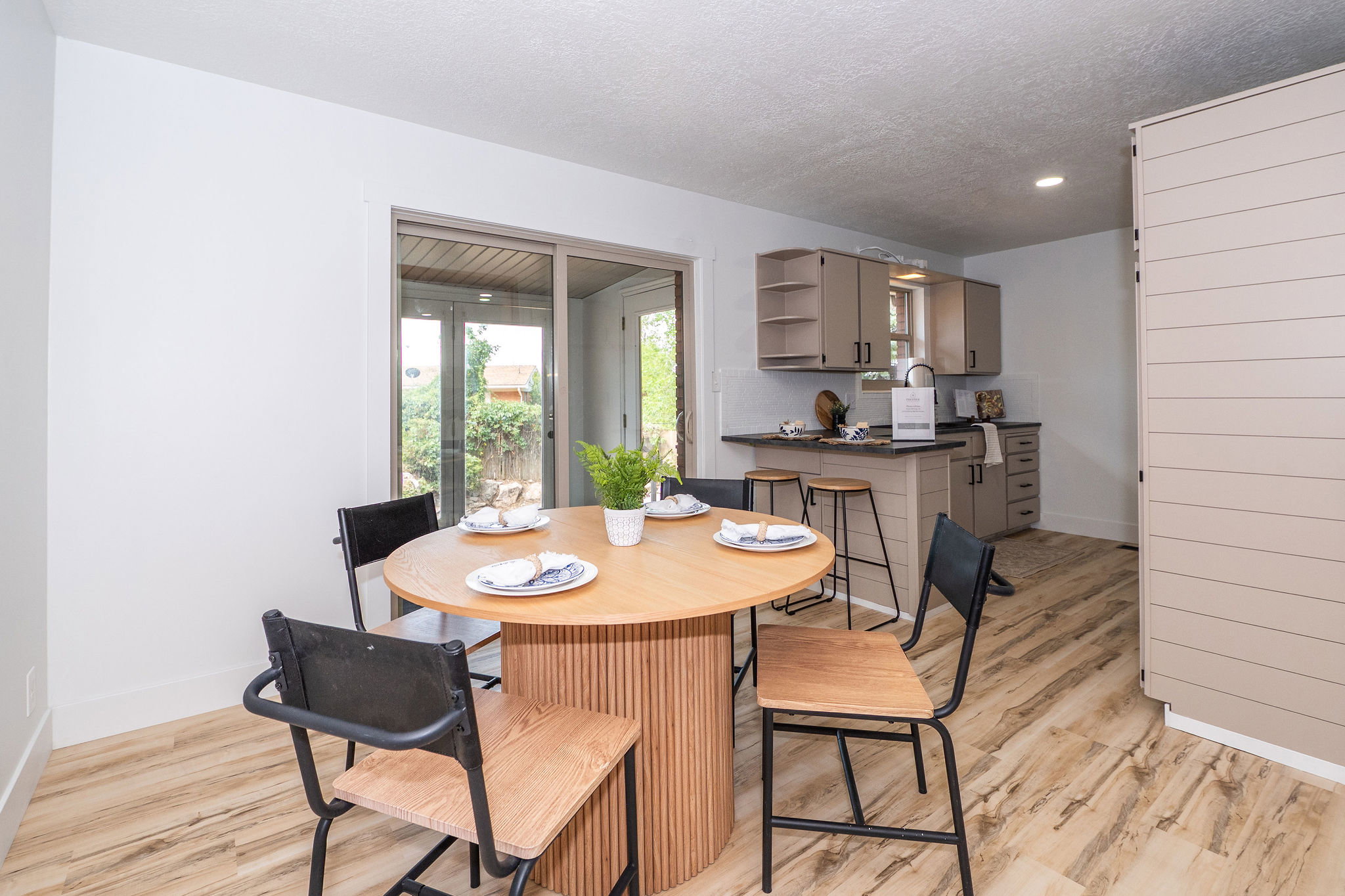 Kitchenette featuring a black countertop, beige cabinetry, and wood-finish flooring