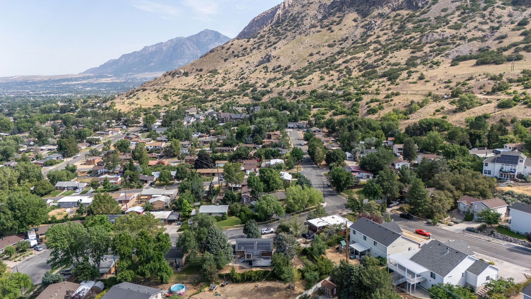 Residential neighborhood featuring mature trees and a mountainous backdrop