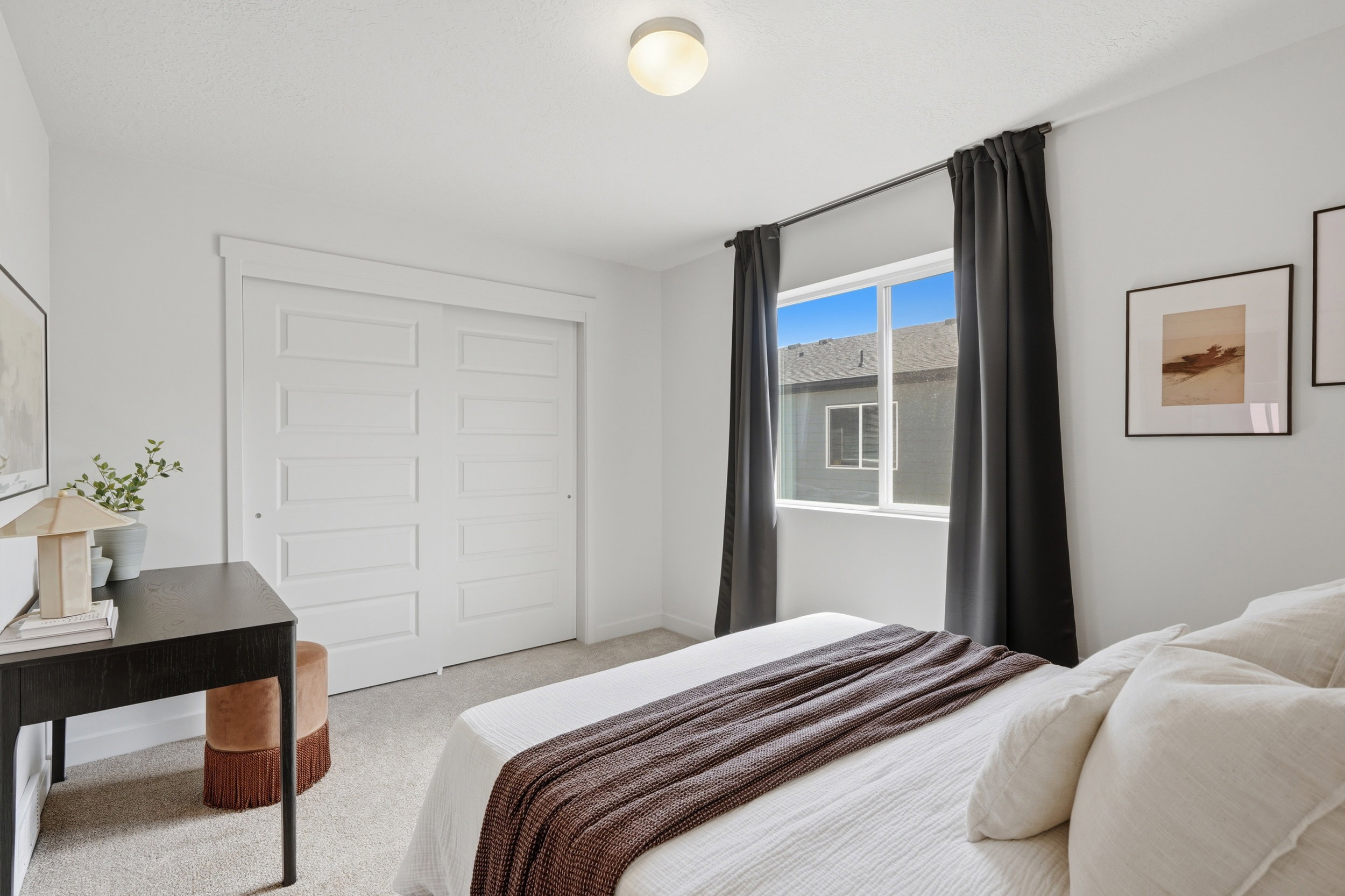 Carpeted bedroom featuring a double-pane window with dark drapery and a flush-mount ceiling light