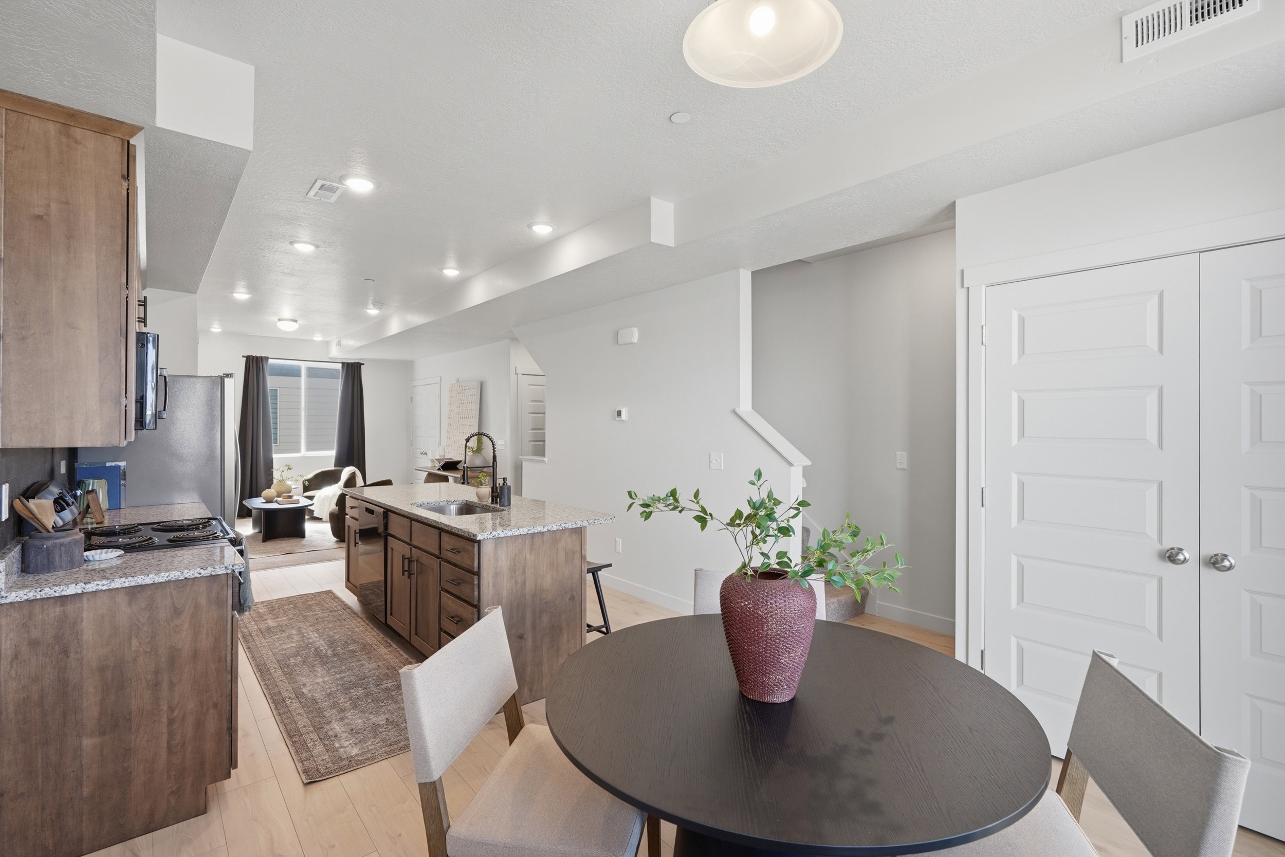 Open-concept kitchen and living area featuring light wood-finish flooring, recessed lighting, and white walls
