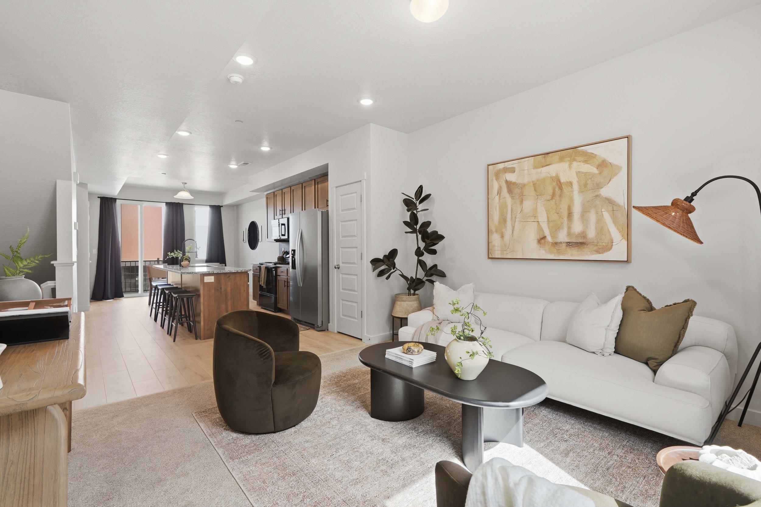 Open-concept living area featuring light wood-finish flooring, recessed lighting, and a neutral color palette