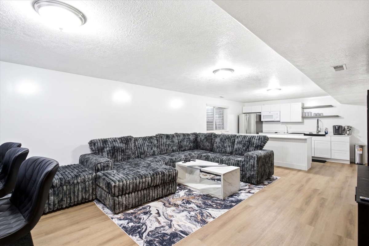 Open-concept living space featuring wood-finish flooring, recessed lighting, and a white color palette