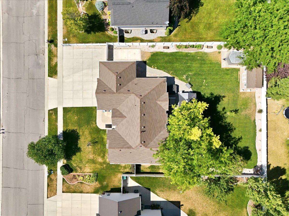 Expansive property featuring a multi-gabled roofline and concrete driveway. Aerial view from above