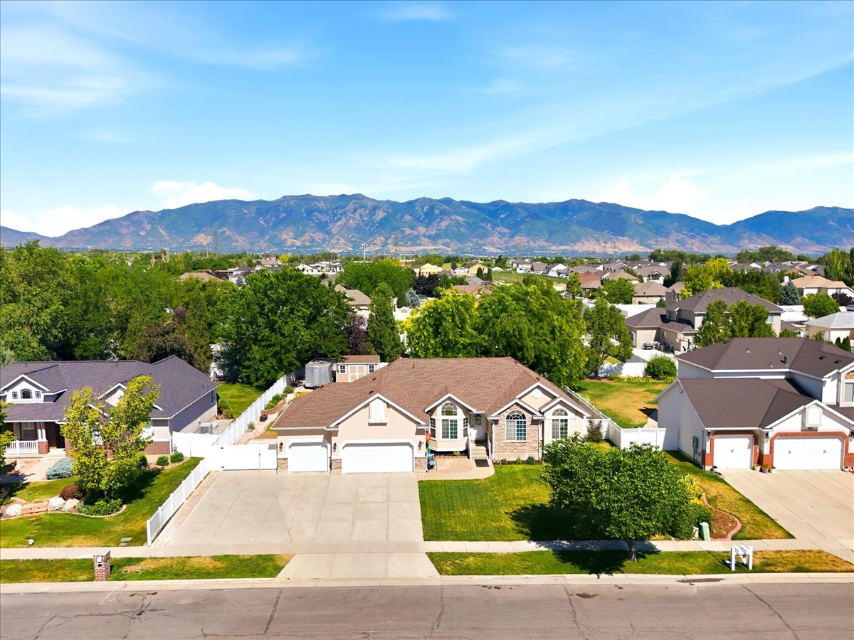 Single-story residence featuring a 3-car garage and a paved driveway. Aerial view of the front of the home