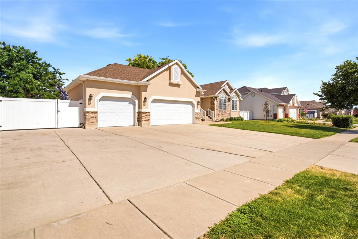 Exterior featuring stucco siding, stone accents, and a 3-car garage