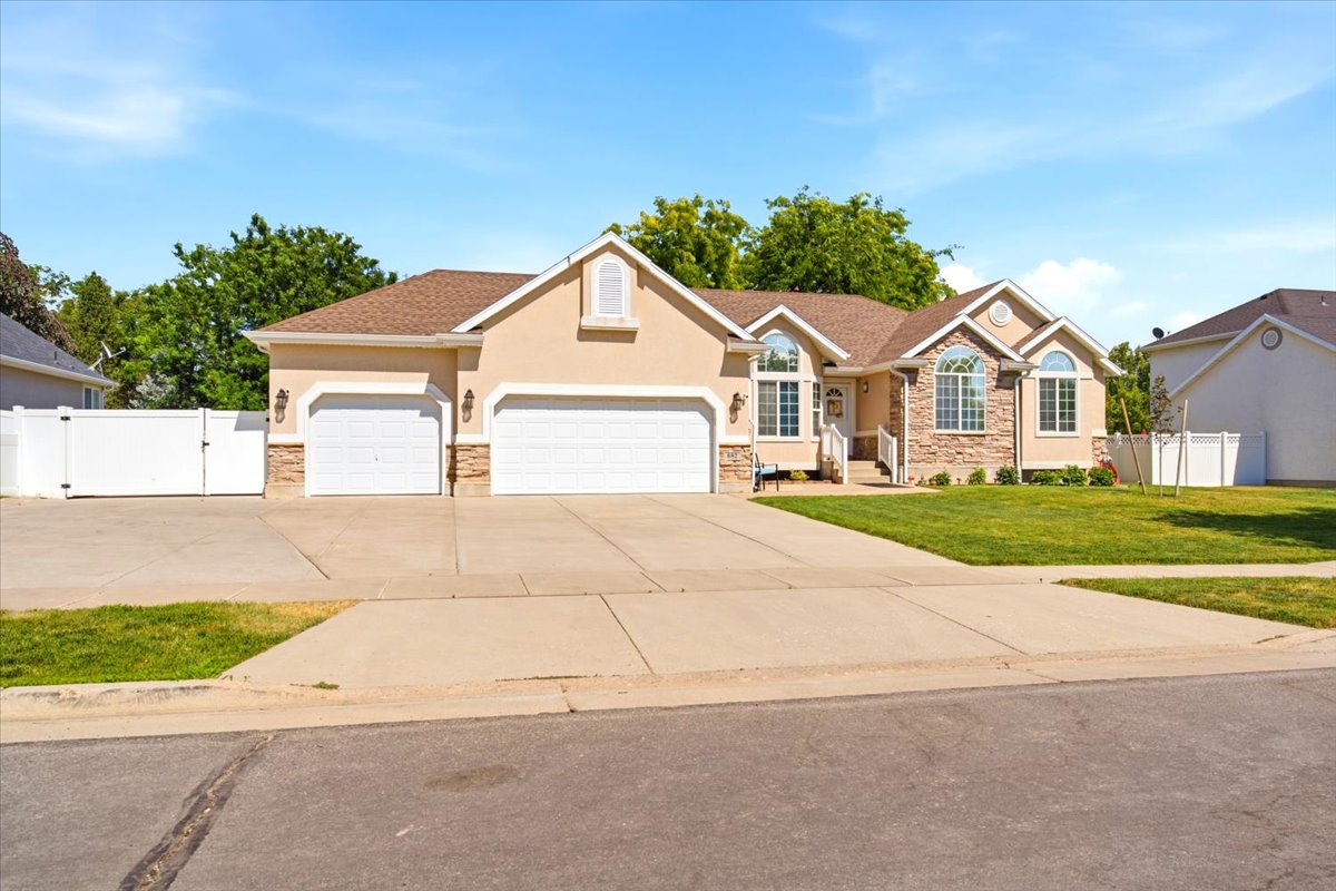 Stucco exterior with stone accents and a multi-car driveway