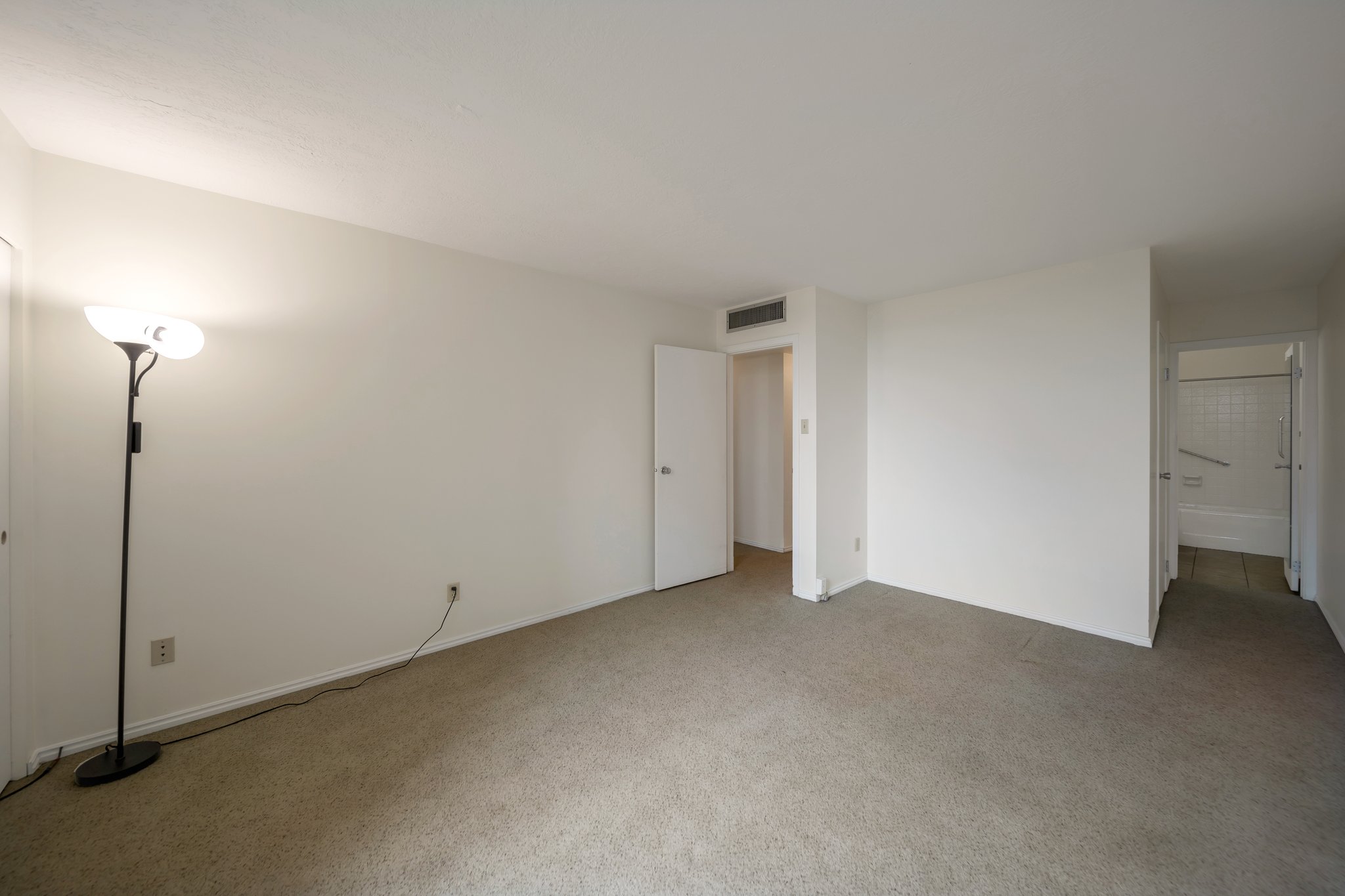 Spacious room featuring neutral carpeting and white wall finishes