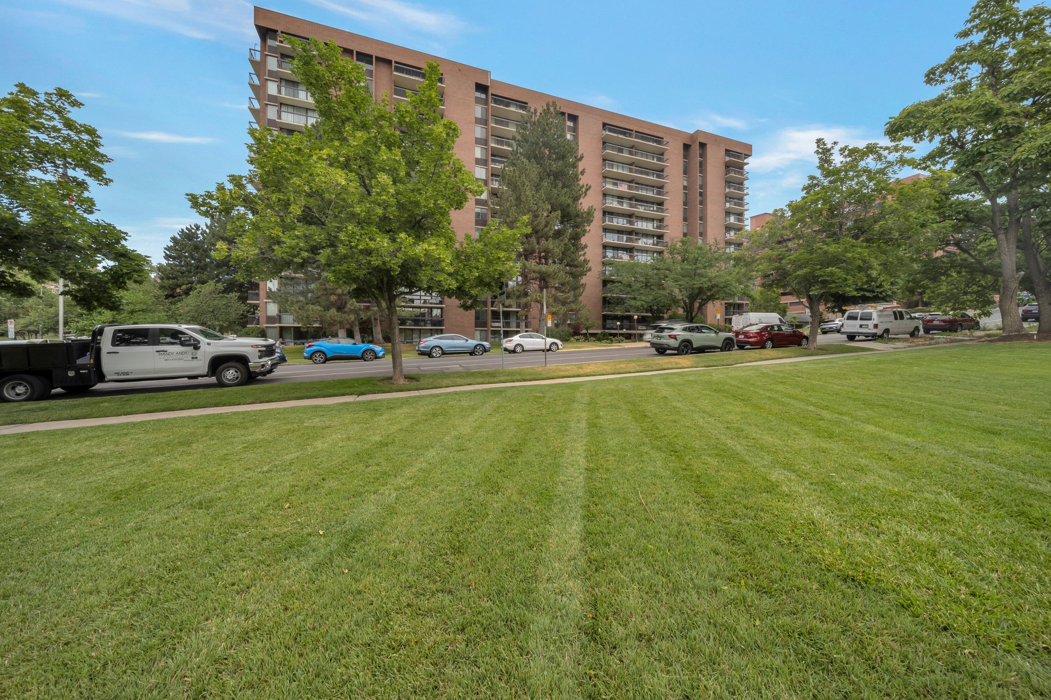 Expansive green lawn bordering a multi-story building with multiple balconies