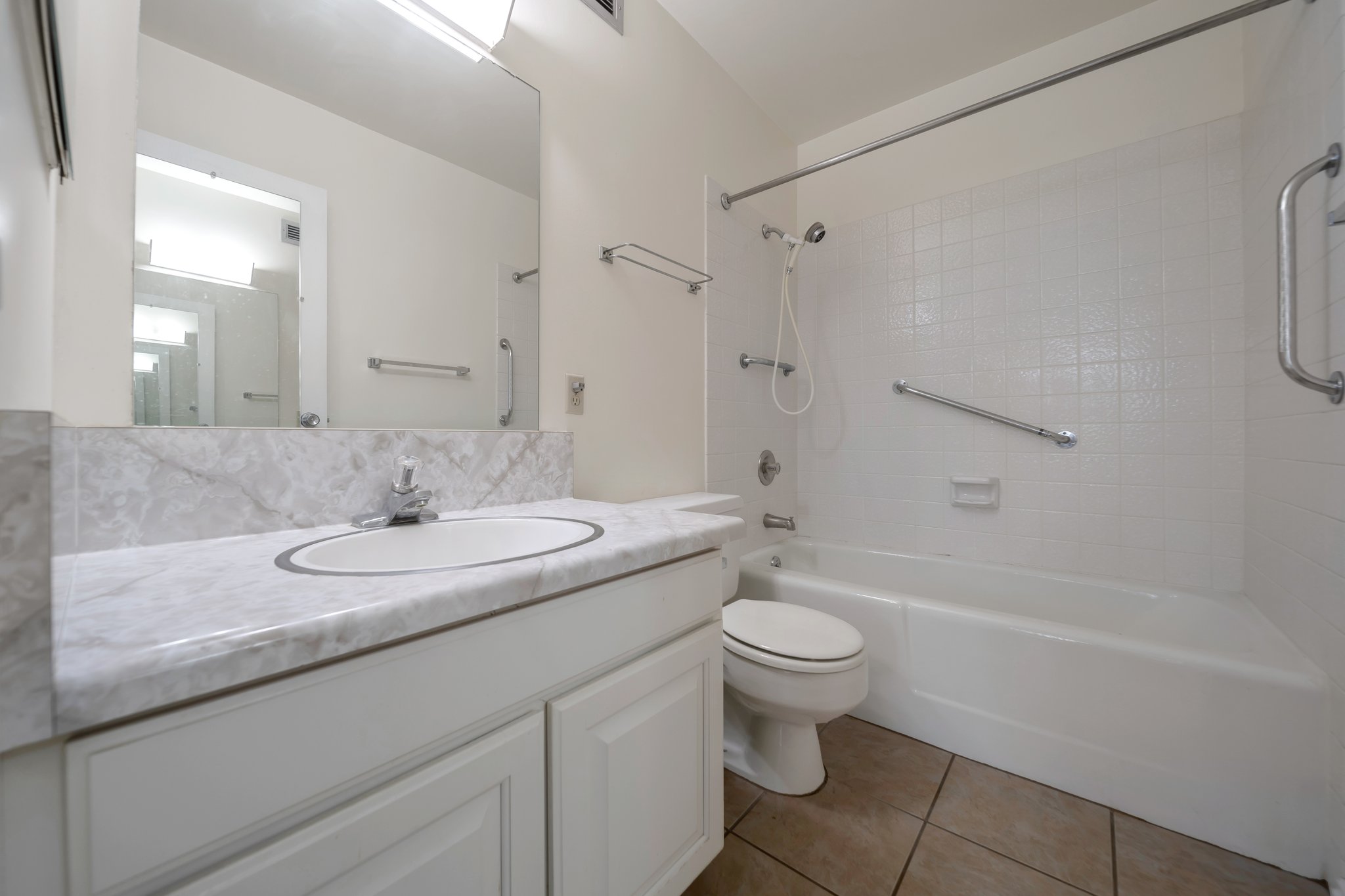 Bathroom featuring a white vanity with an oval undermount sink, a stone-finish countertop, and a full-width mirror