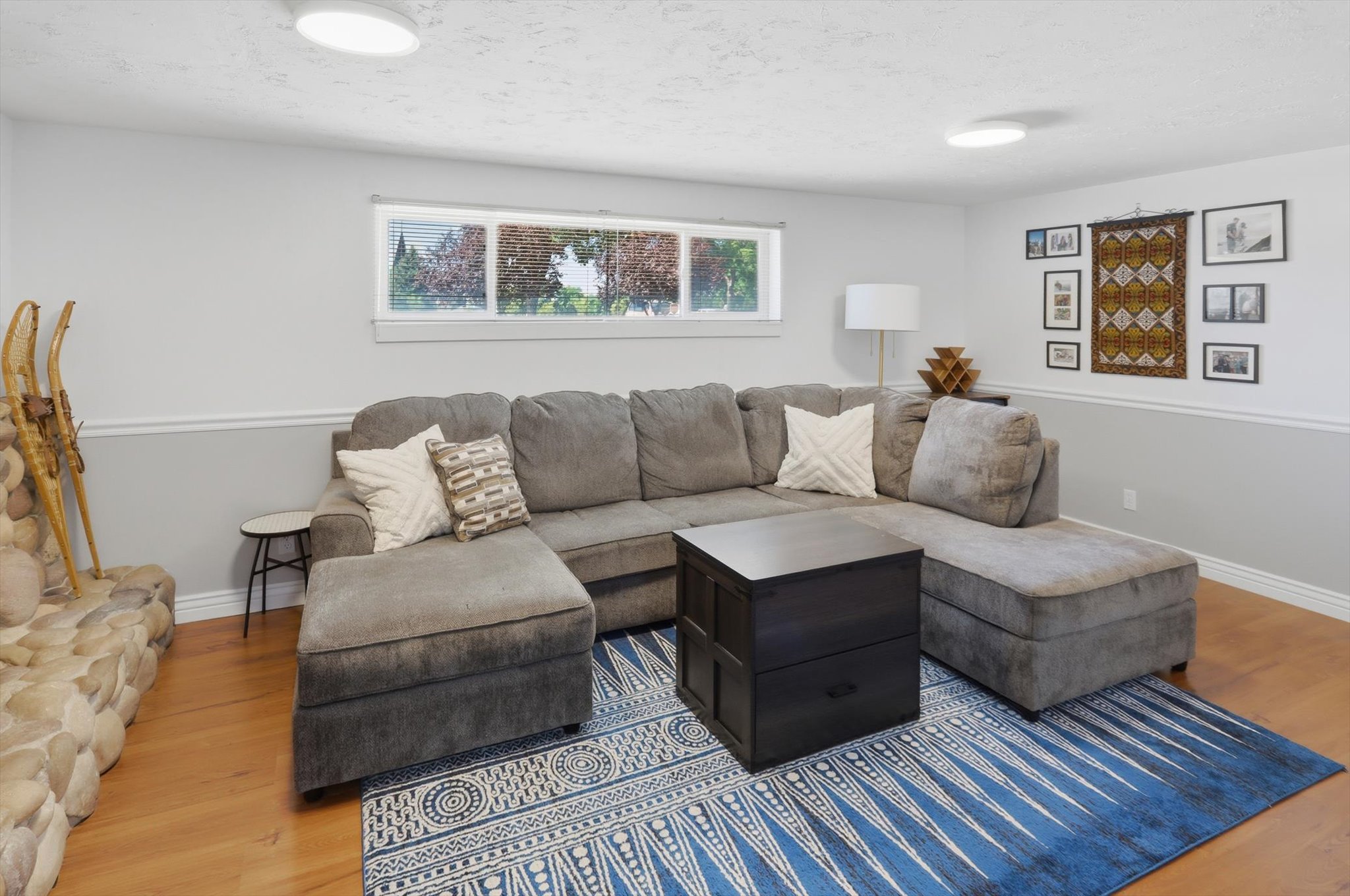 Living area featuring light wood-finish flooring and a stone-clad fireplace