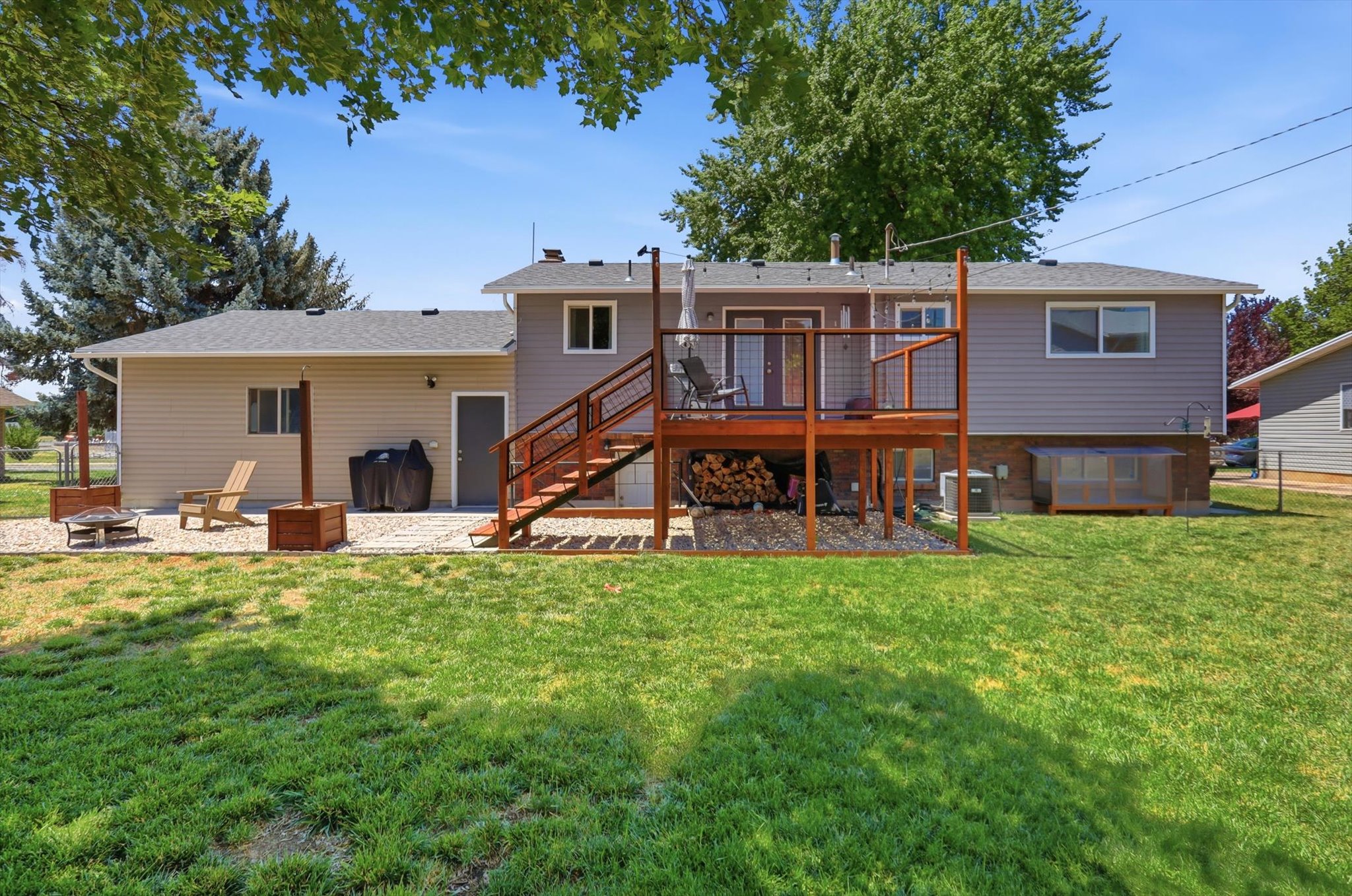 Expansive backyard featuring a large green lawn and mature trees