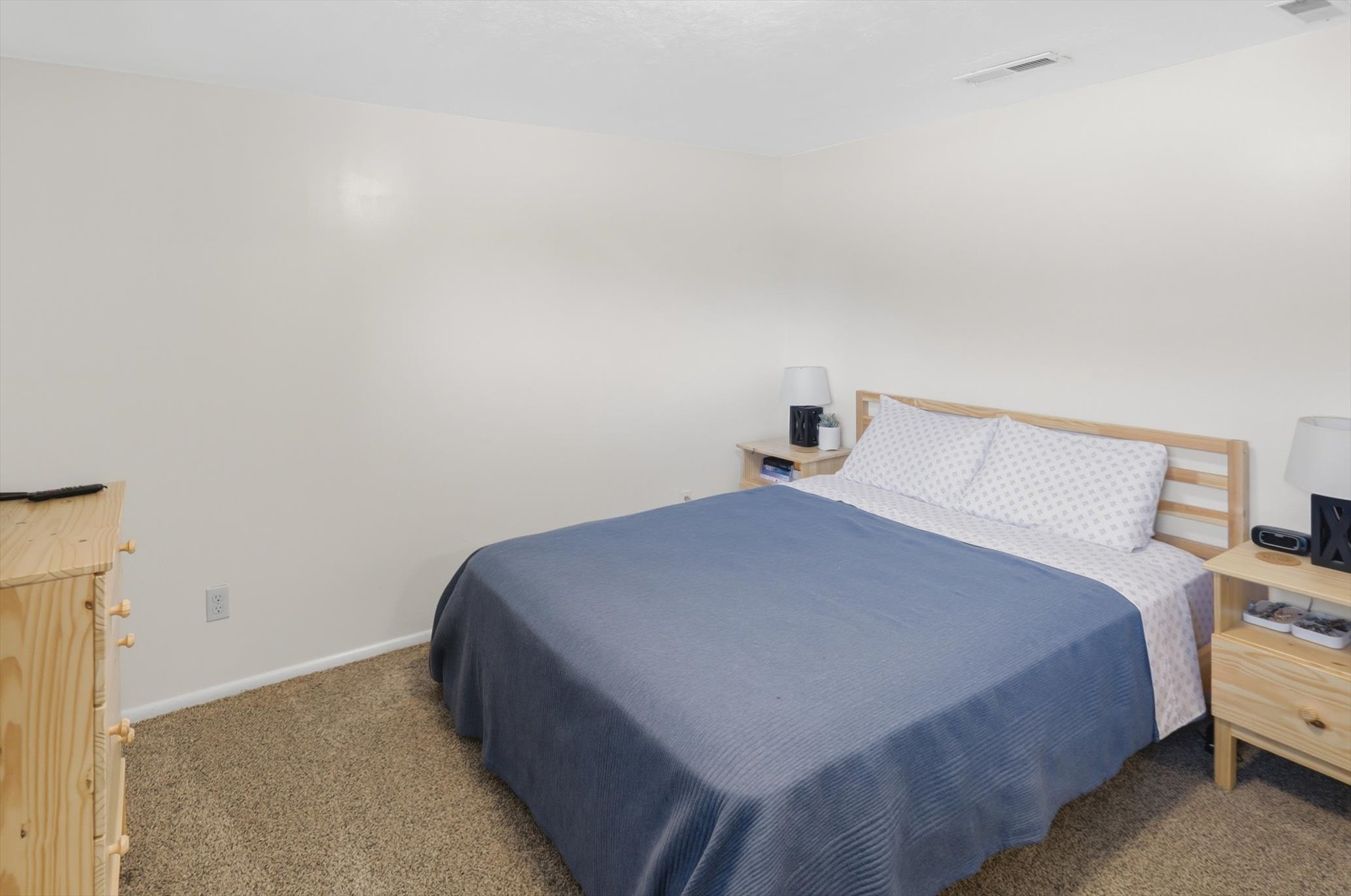 Carpeted room featuring light-toned walls and ceiling