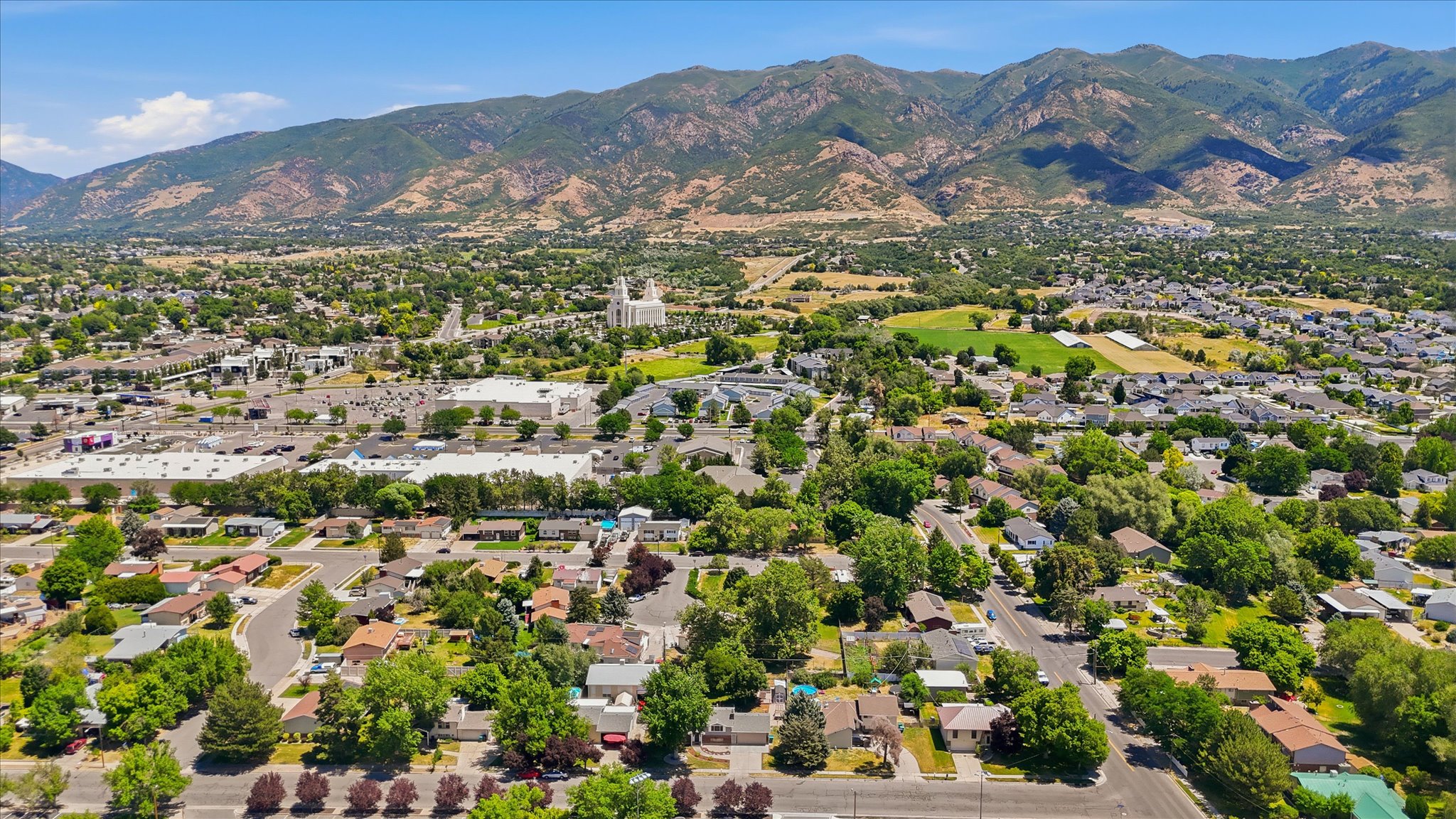 Expansive aerial encompassing a residential neighborhood set against a backdrop of mountains