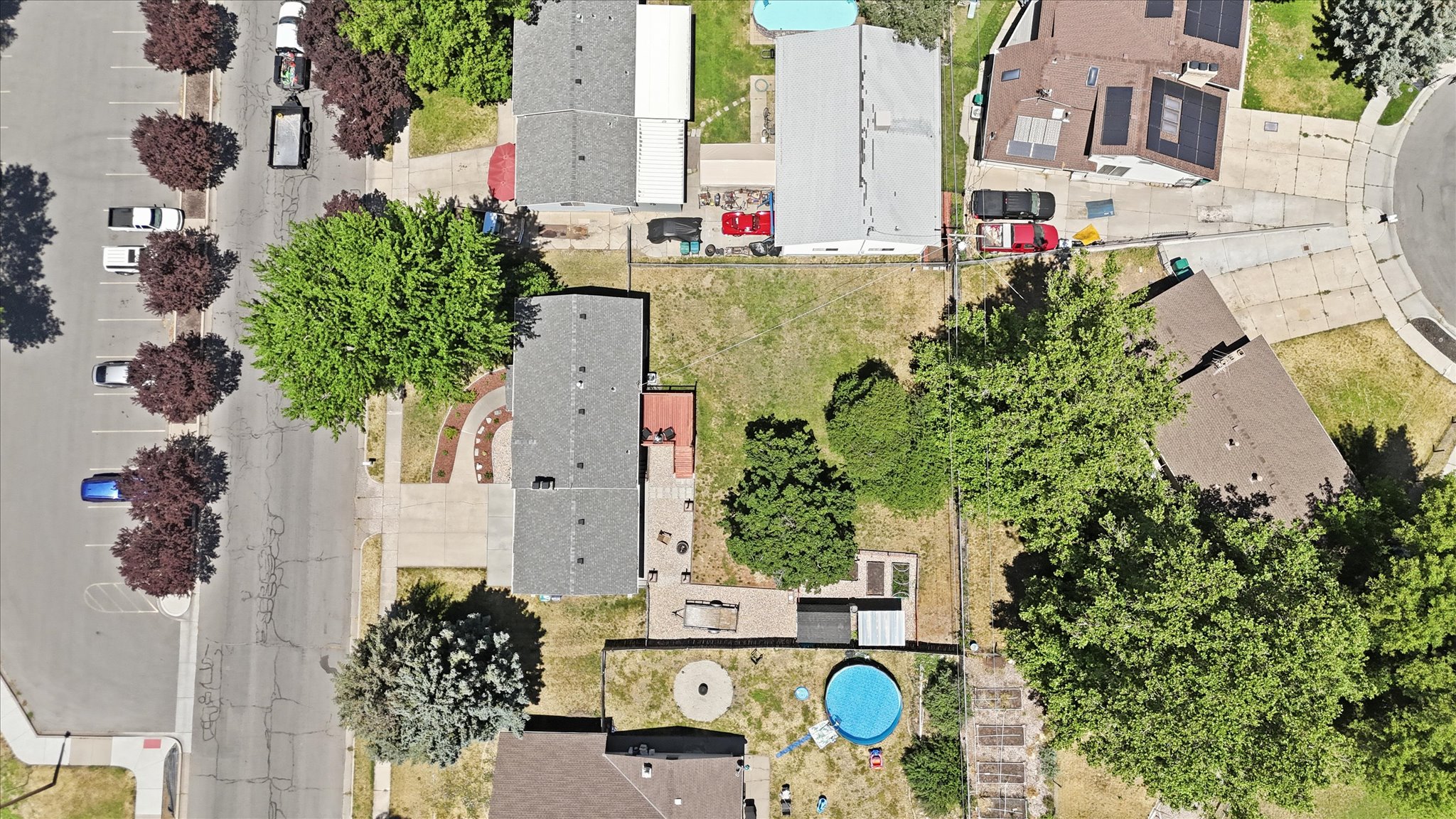 Aerial perspective showcasing a residential property with a concrete driveway, and a partially landscaped front yard