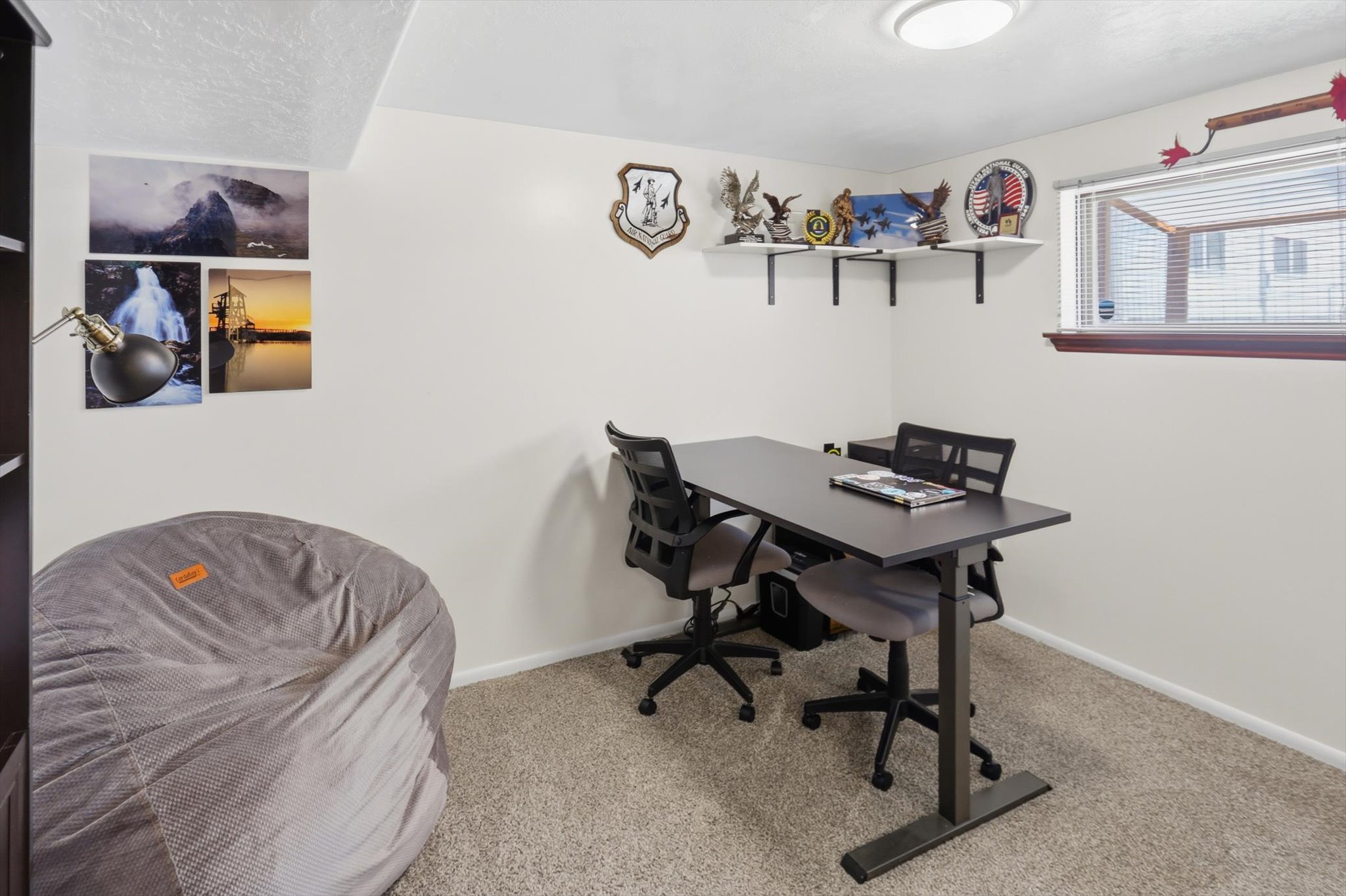 Room featuring neutral-toned carpeting, a window with horizontal blinds, and a built-in recessed ceiling light fixture