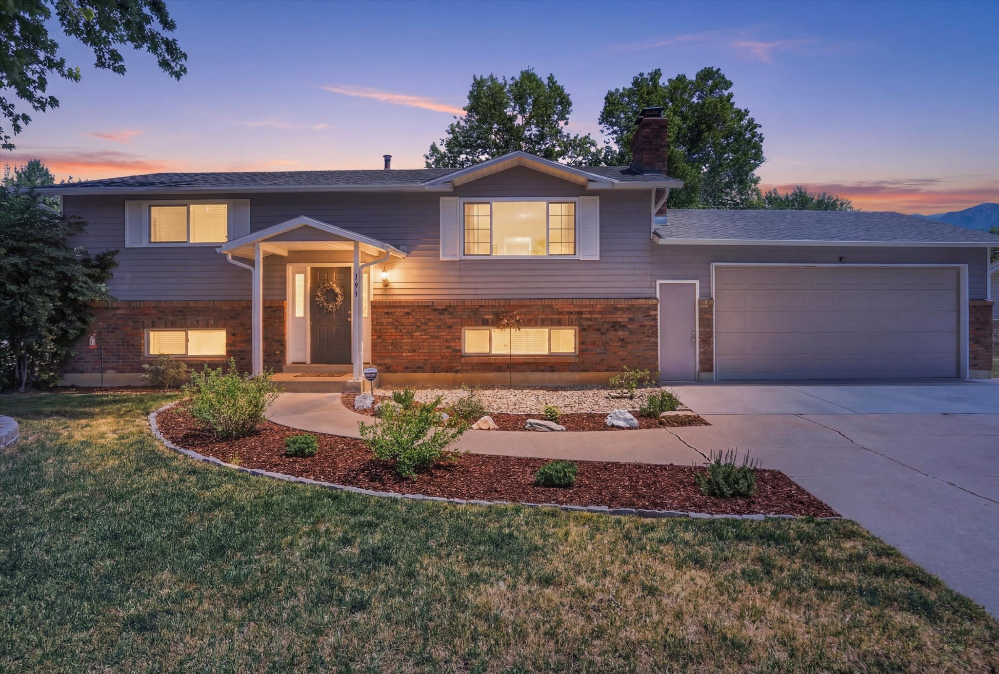 Split-level residence featuring a brick and siding exterior