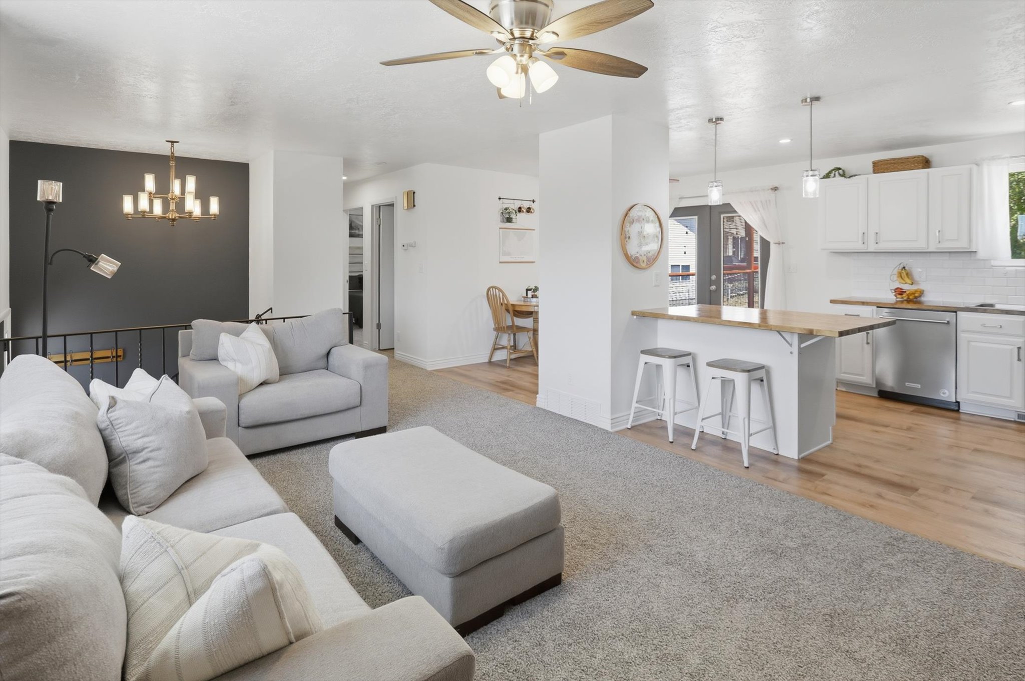 Open-concept living space featuring carpeted flooring and a ceiling fan