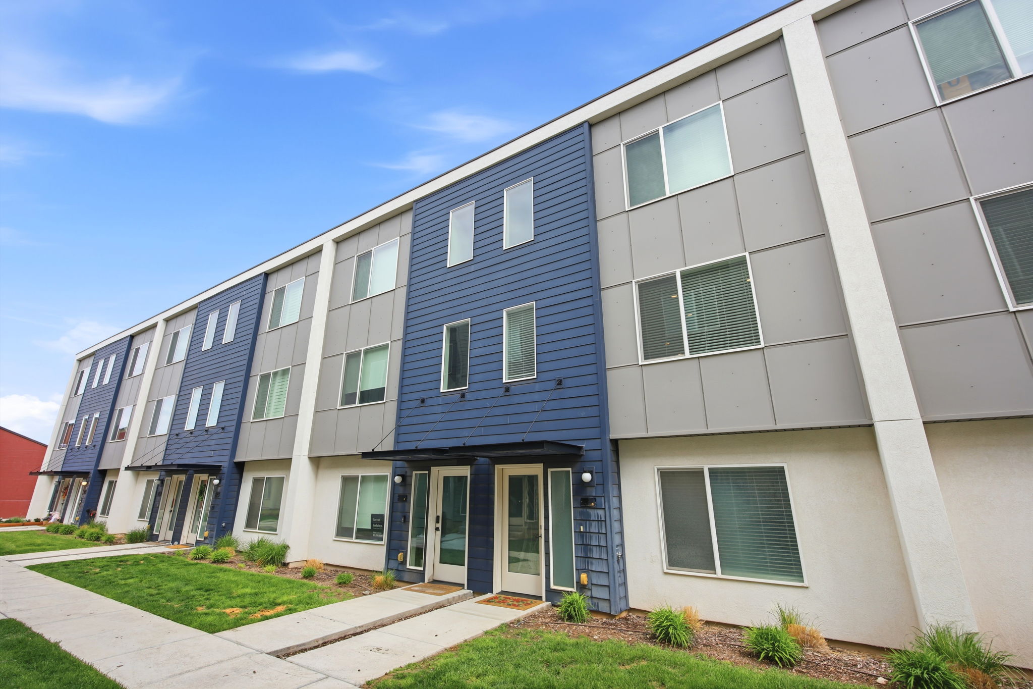Modern multi-story building featuring a blue and gray facade with white trim
