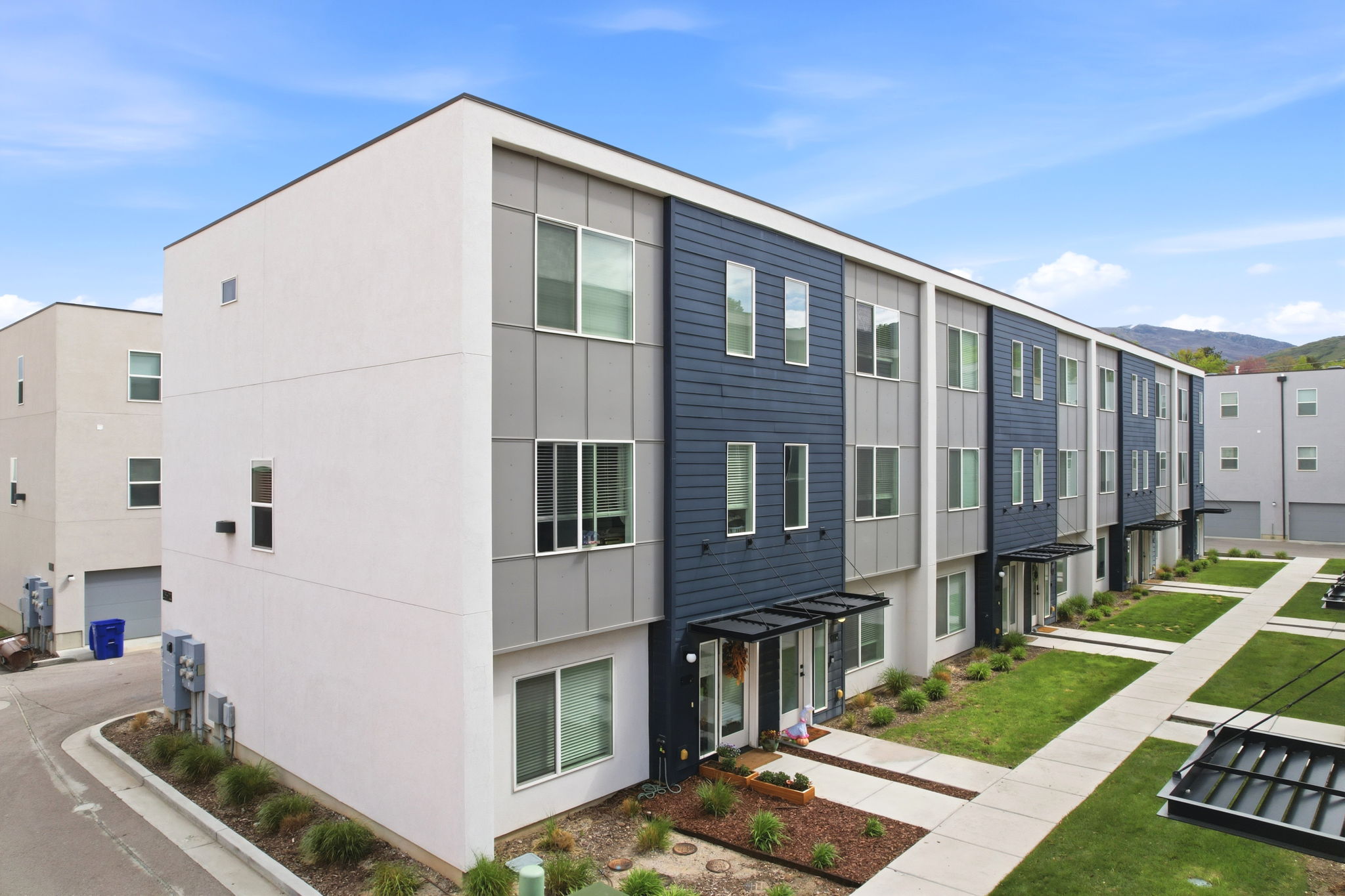Modern townhome architecture featuring a white and dark blue facade