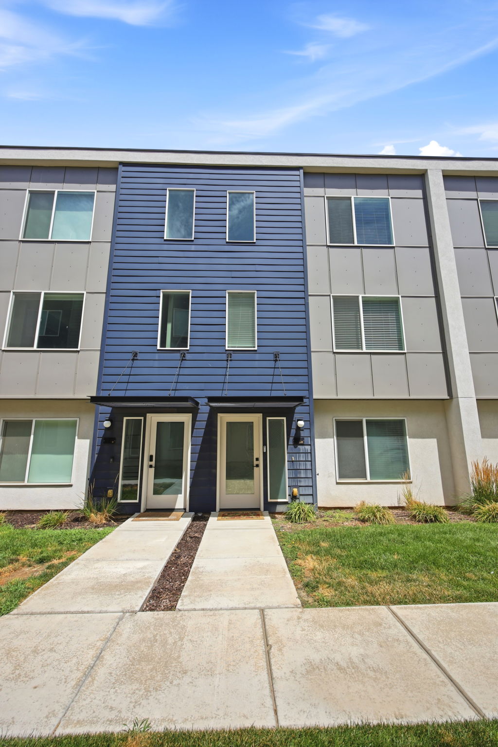 Multi-level contemporary facade featuring a prominent blue horizontal siding section