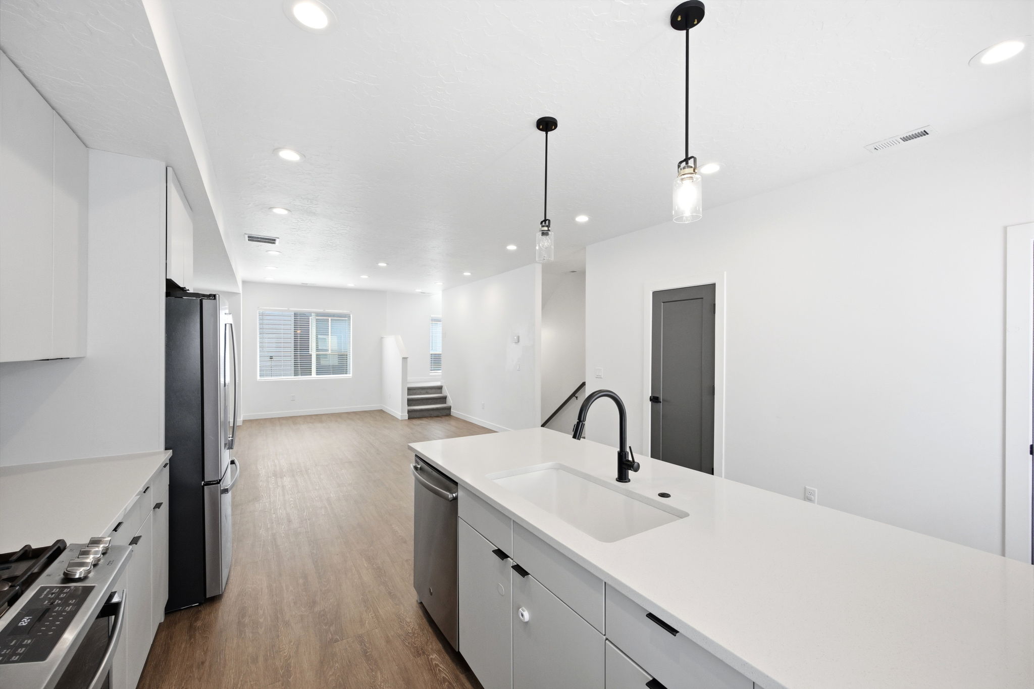 Modern kitchen featuring a large island with an undermount sink and black gooseneck faucet