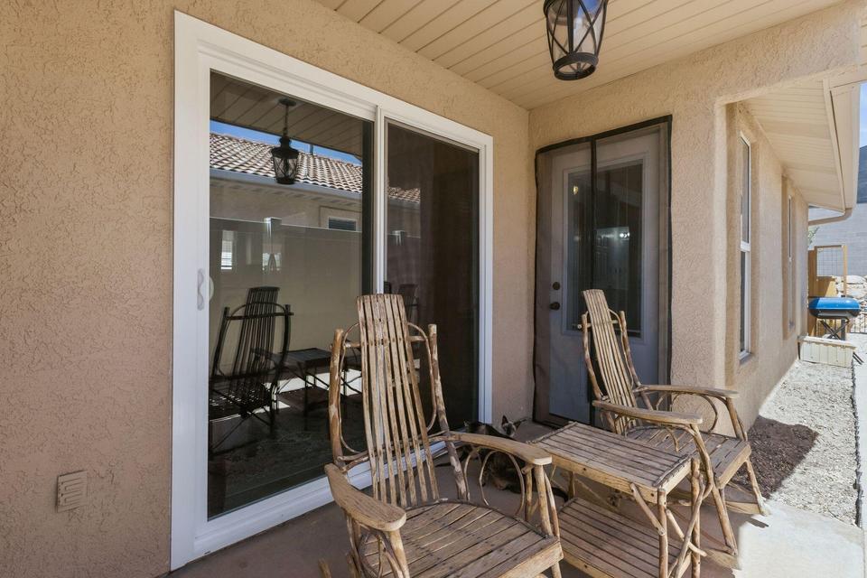 Covered patio featuring a sliding glass door, an additional exterior door, and stucco siding