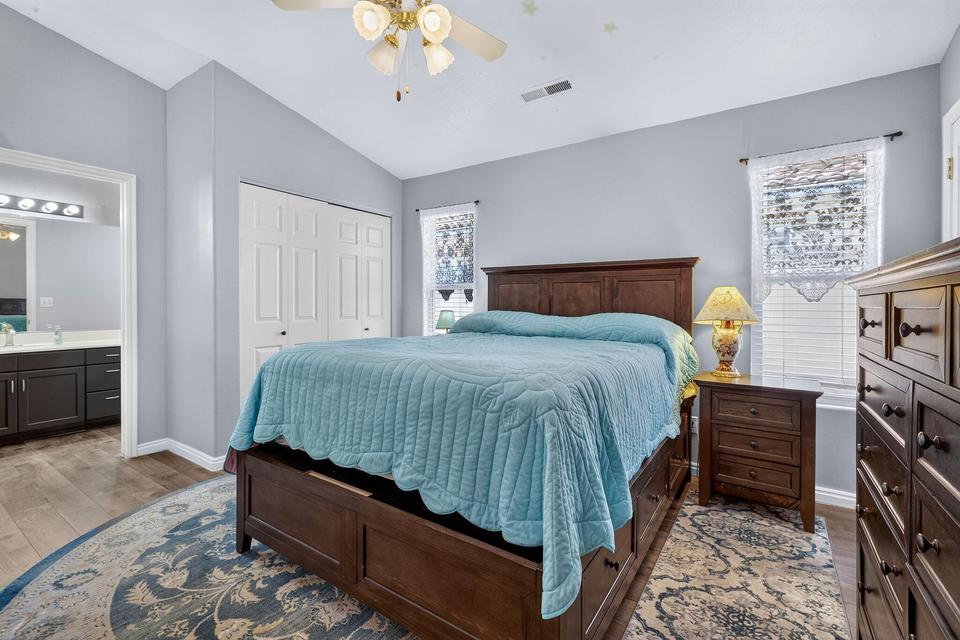 Vaulted ceiling bedroom featuring wood-finish flooring and a ceiling fan with integrated lighting