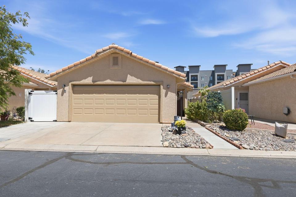 Stucco exterior featuring a two-car garage, concrete driveway, and a tile roof
