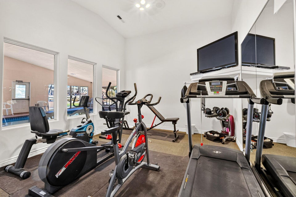 Dedicated fitness space featuring a vaulted ceiling and recessed lighting