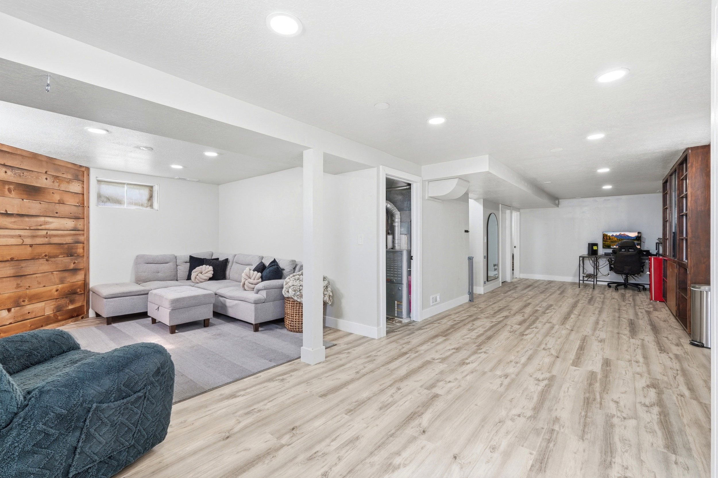 Spacious lower-level area featuring recessed lighting, light wood-finish flooring, and a barn wood accent wall