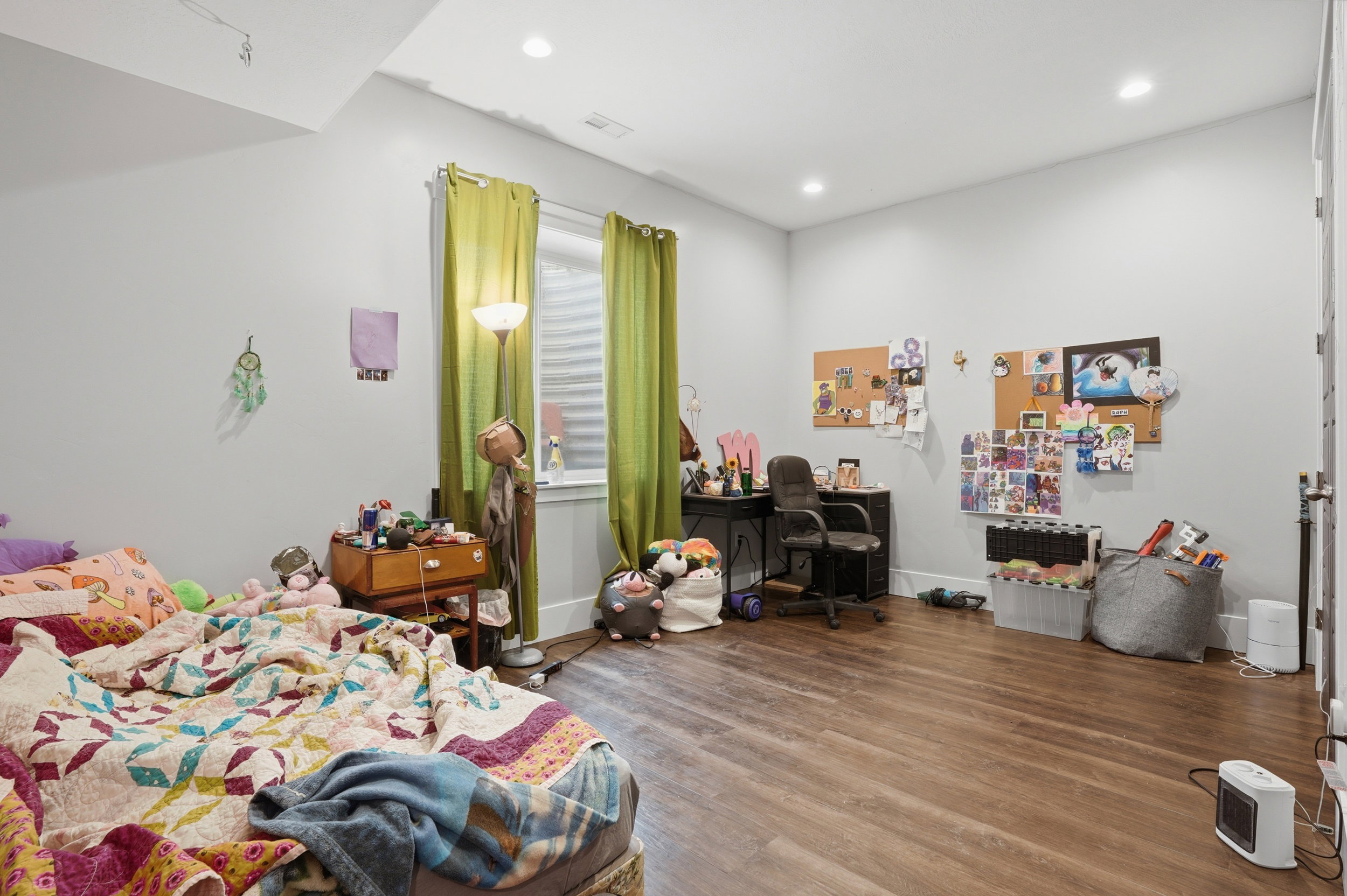 Spacious room featuring wood-finish flooring and recessed lighting
