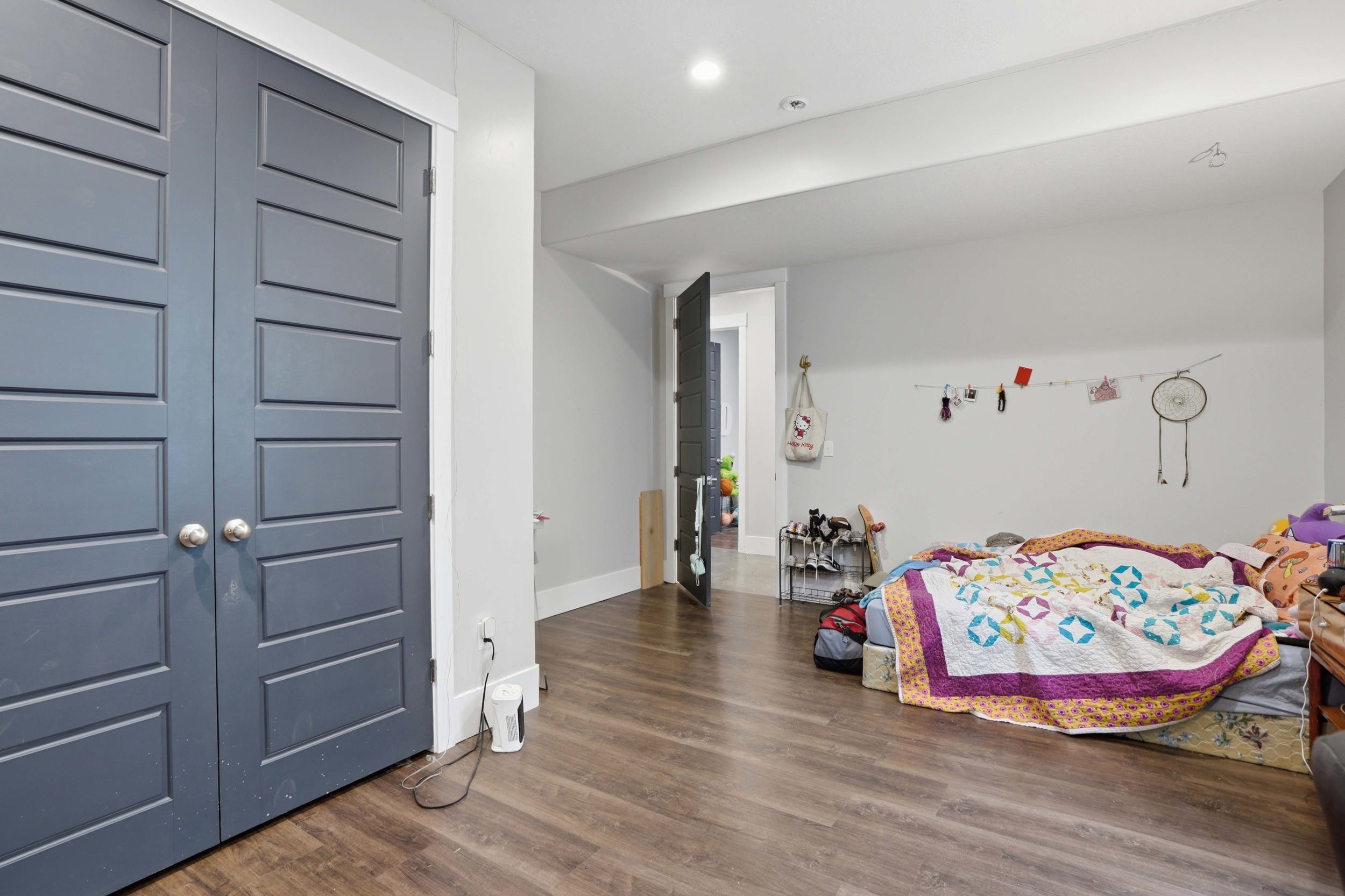 Spacious room featuring wood-finish flooring, light grey walls, and recessed lighting