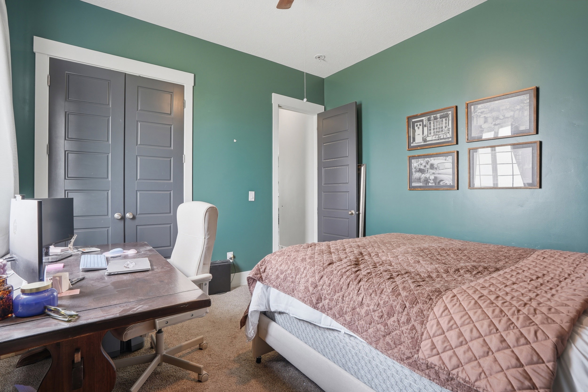 Room featuring an accent wall, neutral carpeting, and a ceiling fan