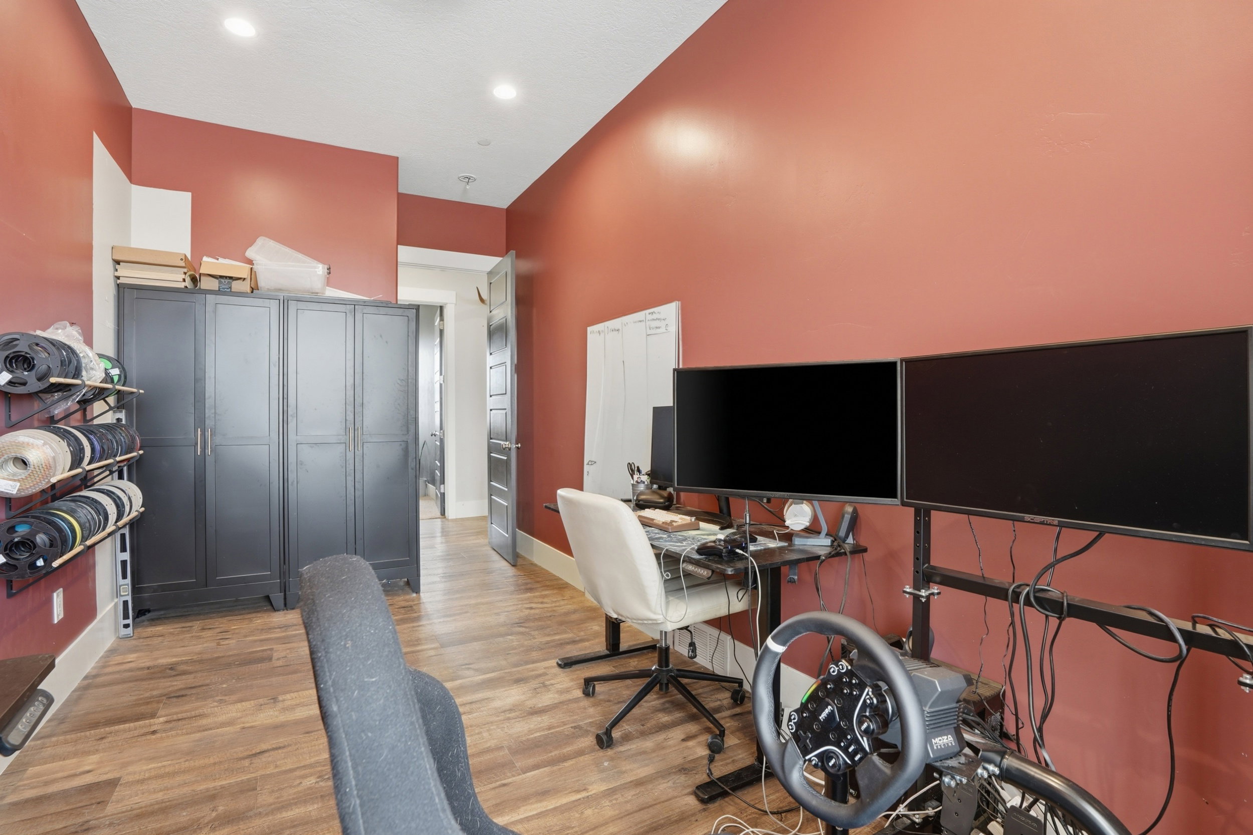 Room featuring wood-finish flooring, recessed lighting, and a built-in storage cabinet