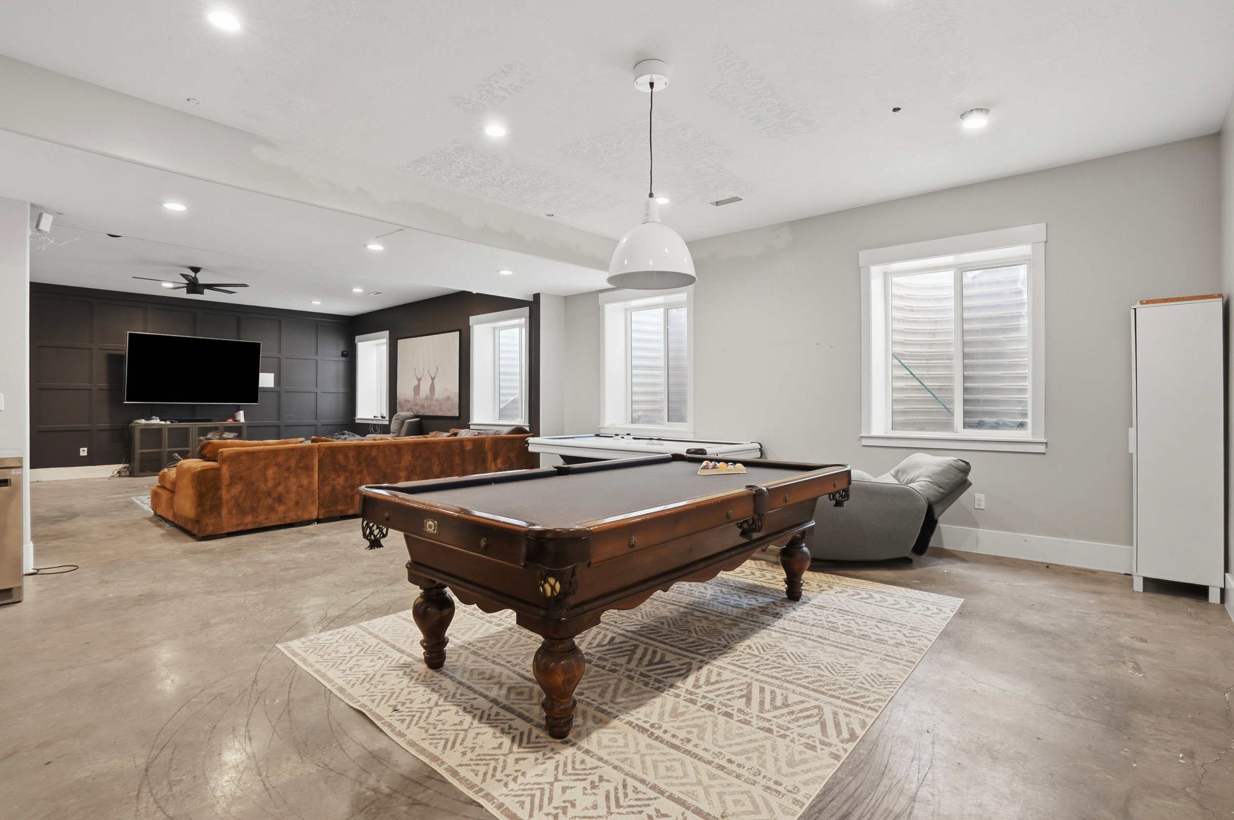 Spacious recreation room featuring concrete flooring and recessed lighting
