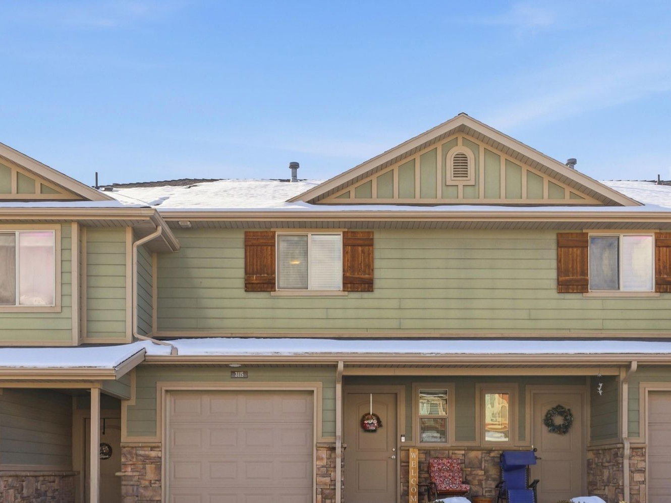 Craftsman-style house with stone siding, board and batten siding, driveway, a garage, and covered porch