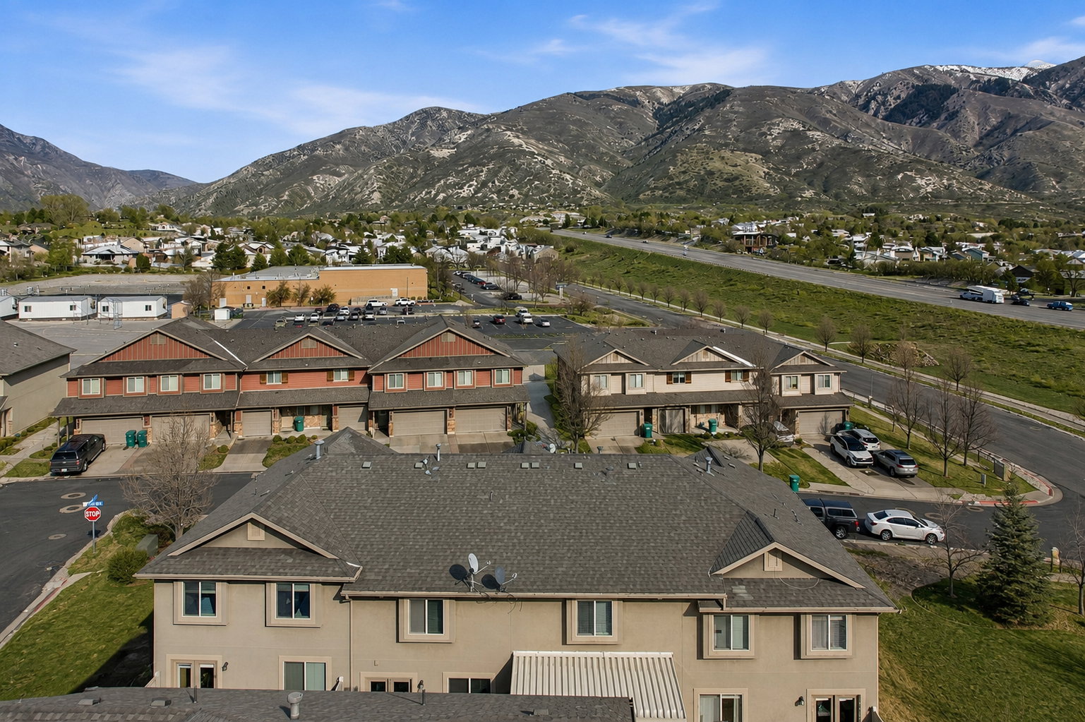 Aerial perspective showcasing multiple properties with mountain scenery