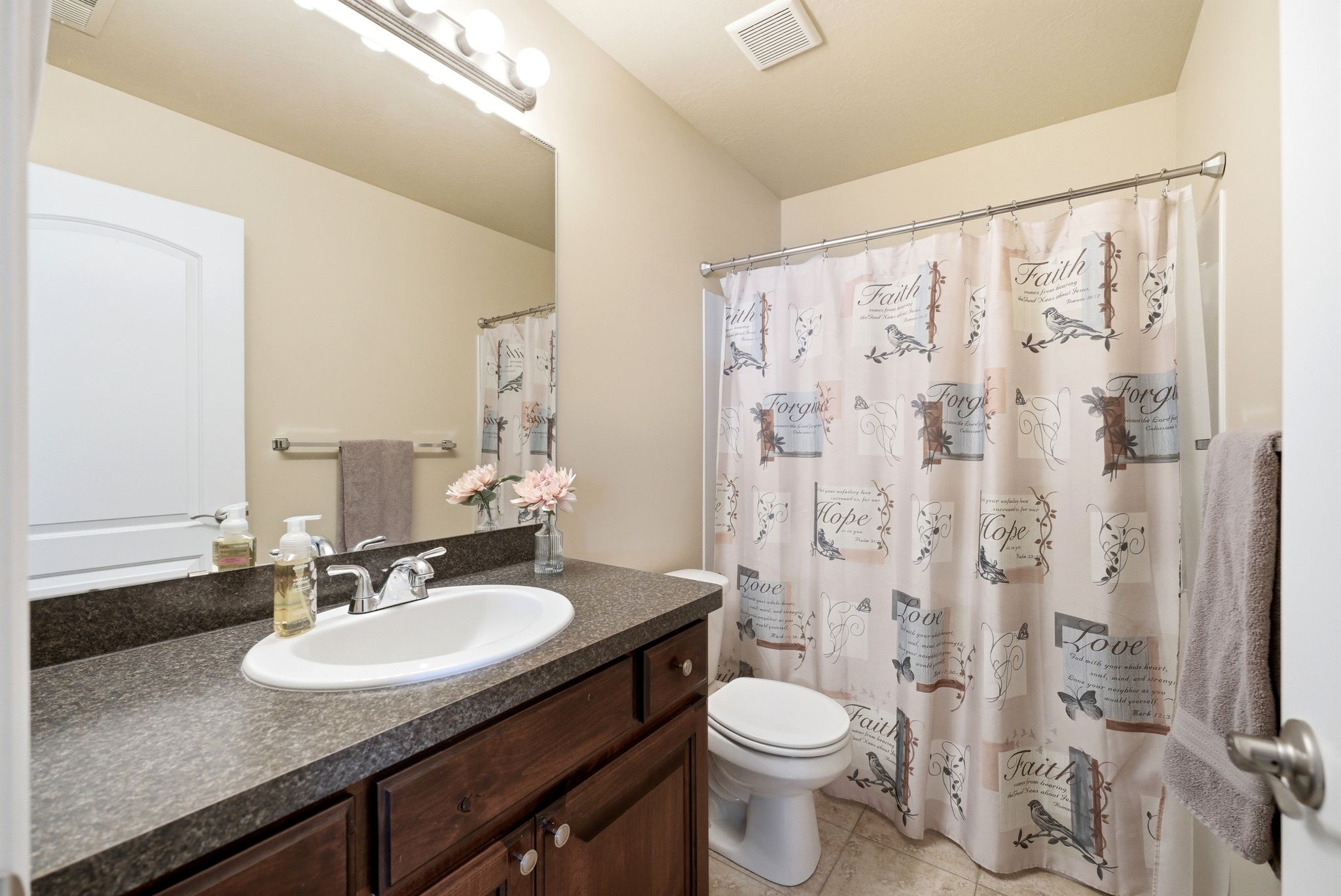 Full bathroom featuring vanity, curtained shower, and light tile patterned floors