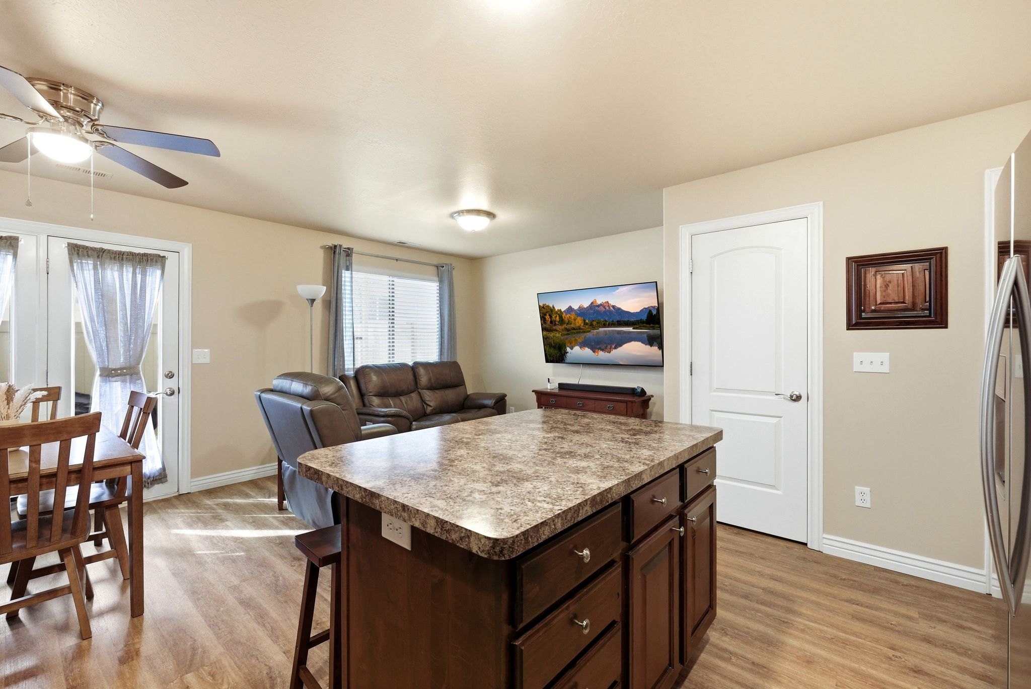 Kitchen with a center island, open floor plan, dark wood finish cabinets, and light wood-style floors