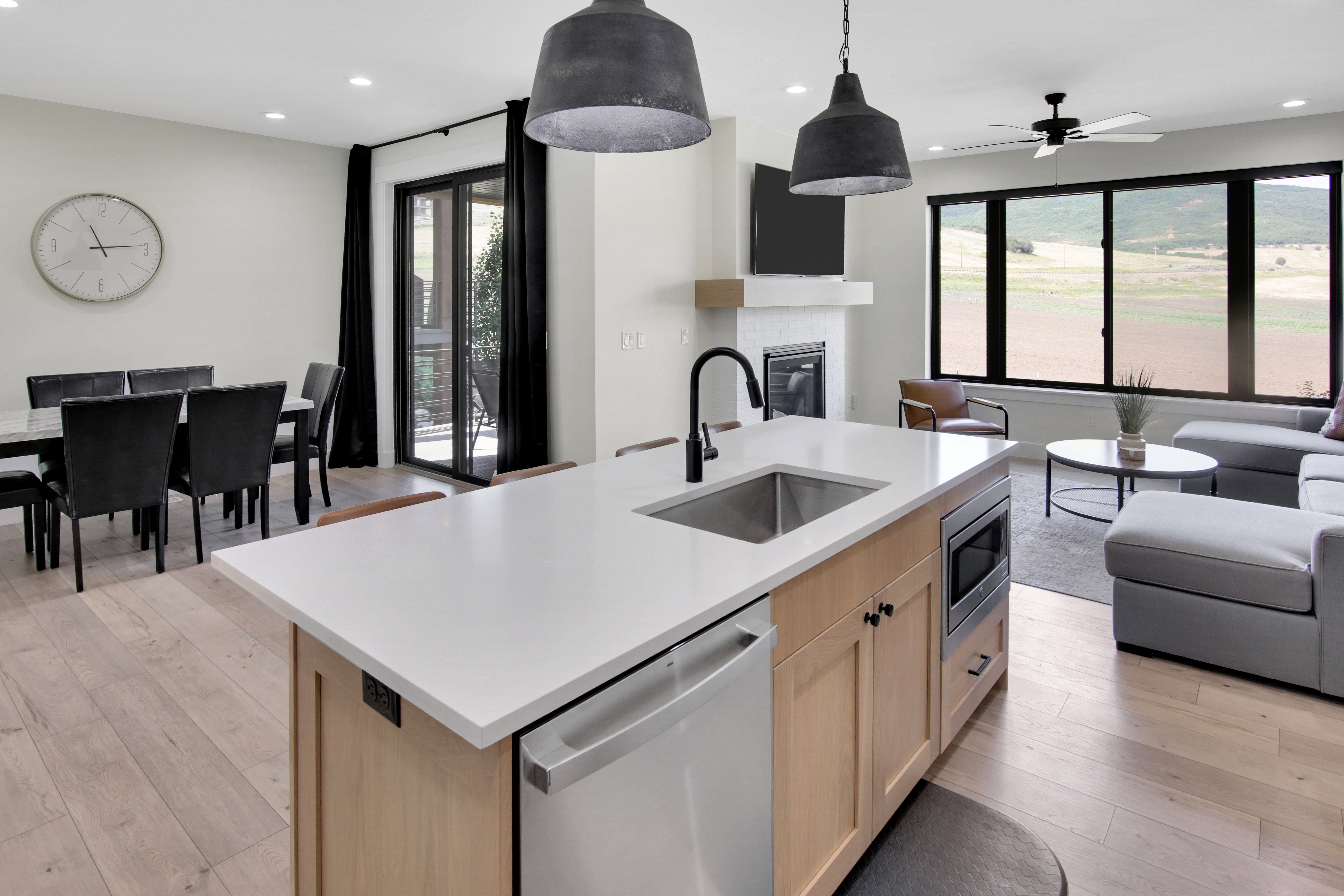 Kitchen island featuring a stainless steel sink with a matte black faucet, integrated dishwasher, and built-in microwave