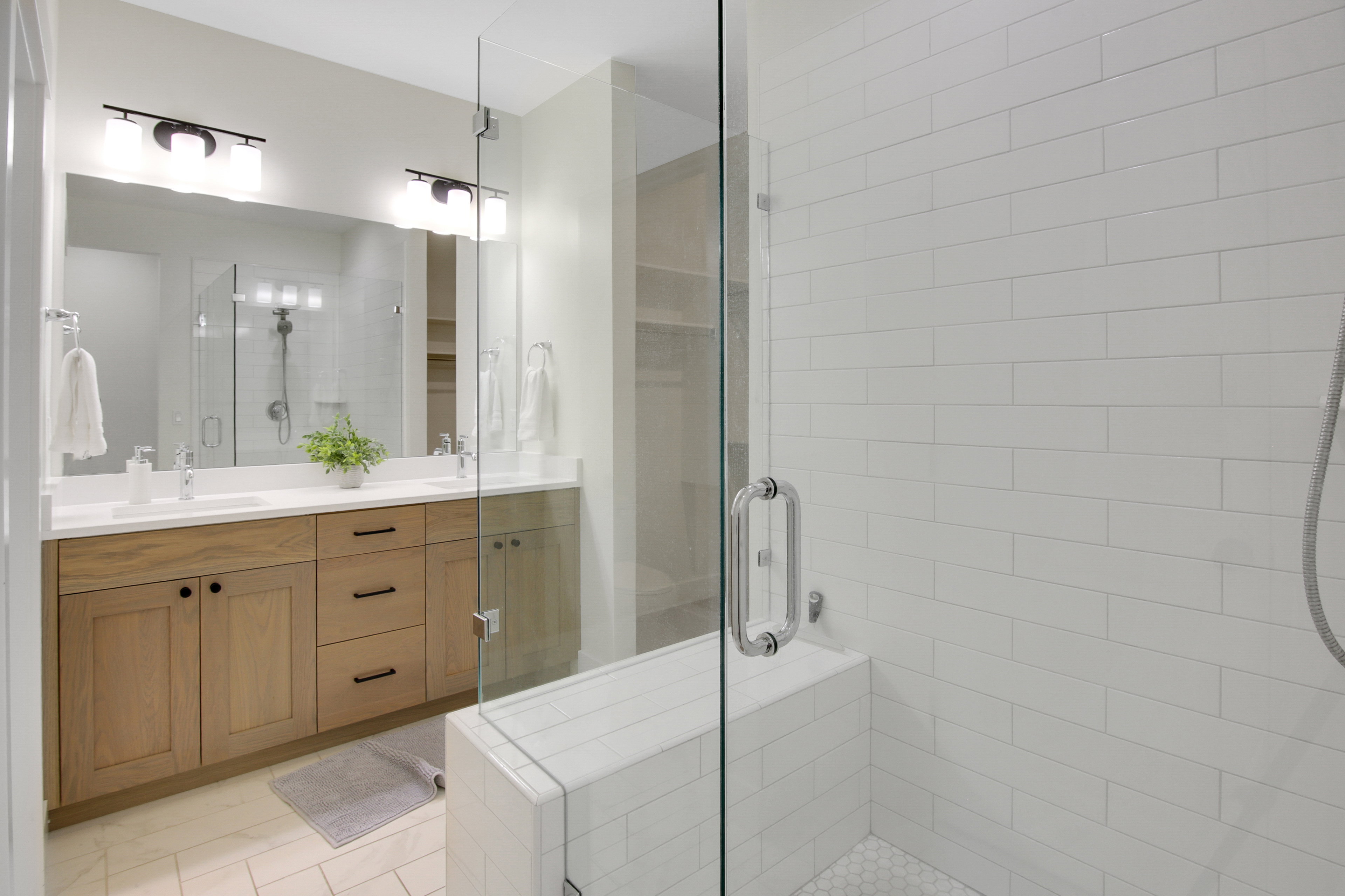 Double vanity with wood-finish cabinetry, white countertop, and dual sinks