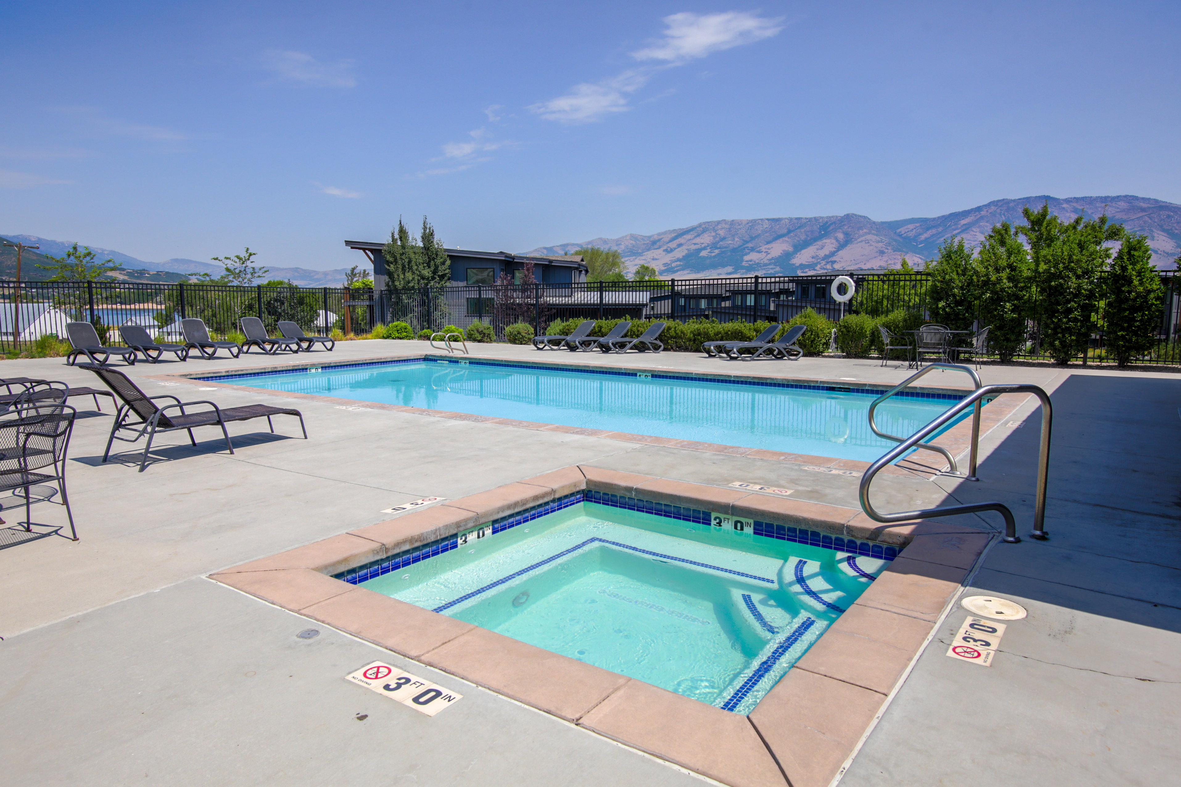 Outdoor swimming pool and spa with mountain scenery