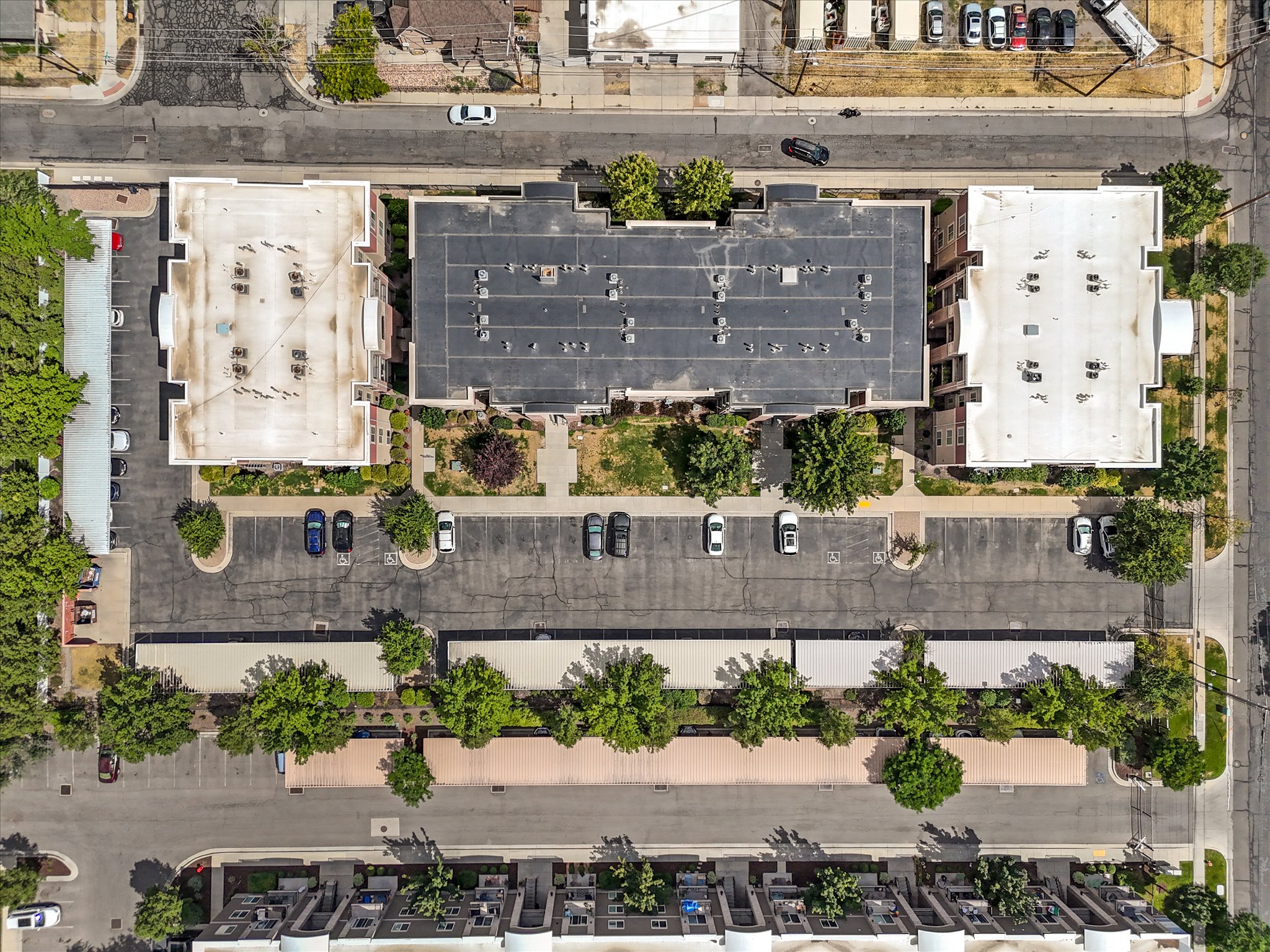 Aerial overview of a multi-building complex featuring extensive paved parking areas