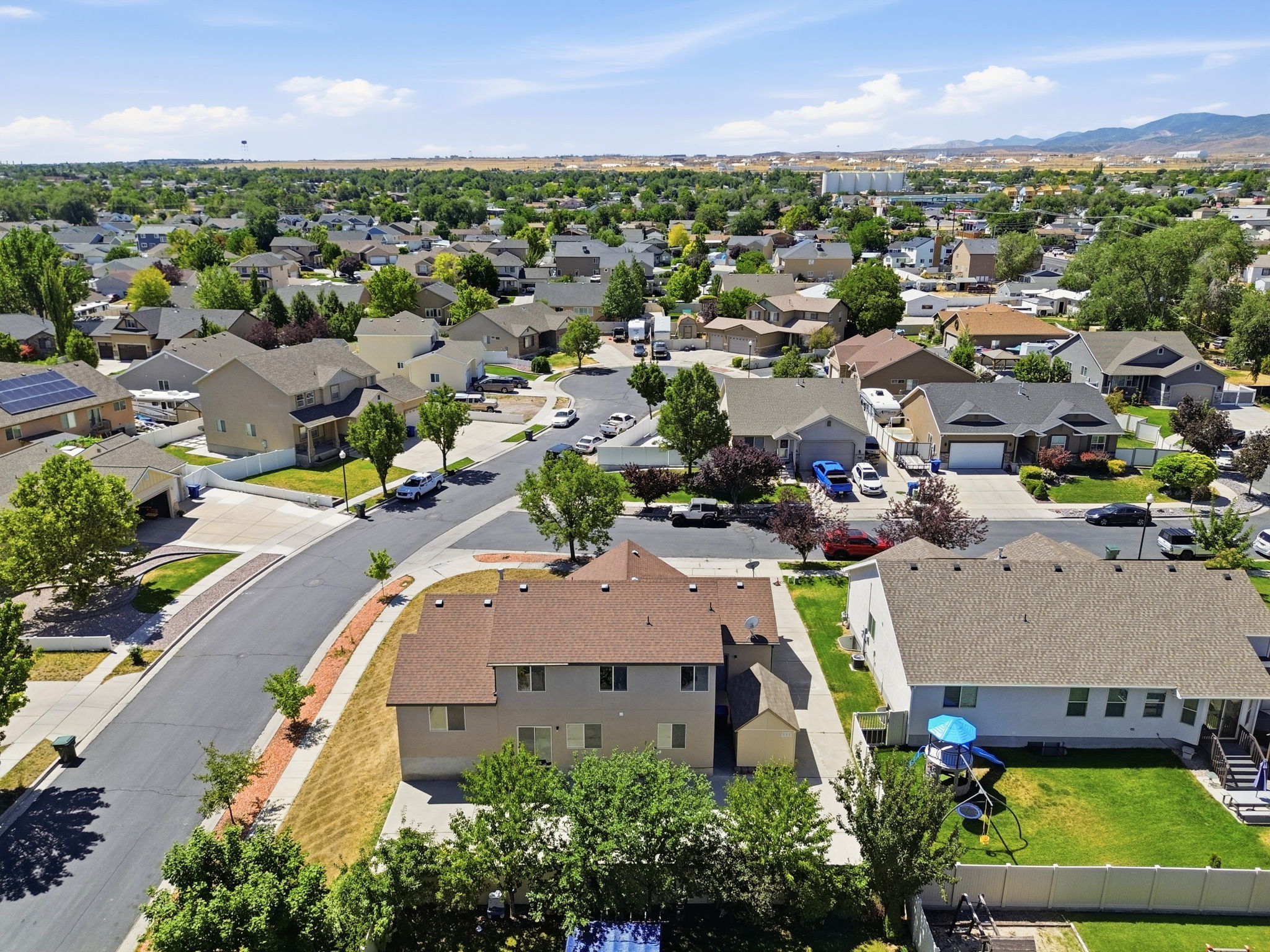 Aerial perspective showcasing a residential neighborhood with varied architectural styles and abundant mature trees
